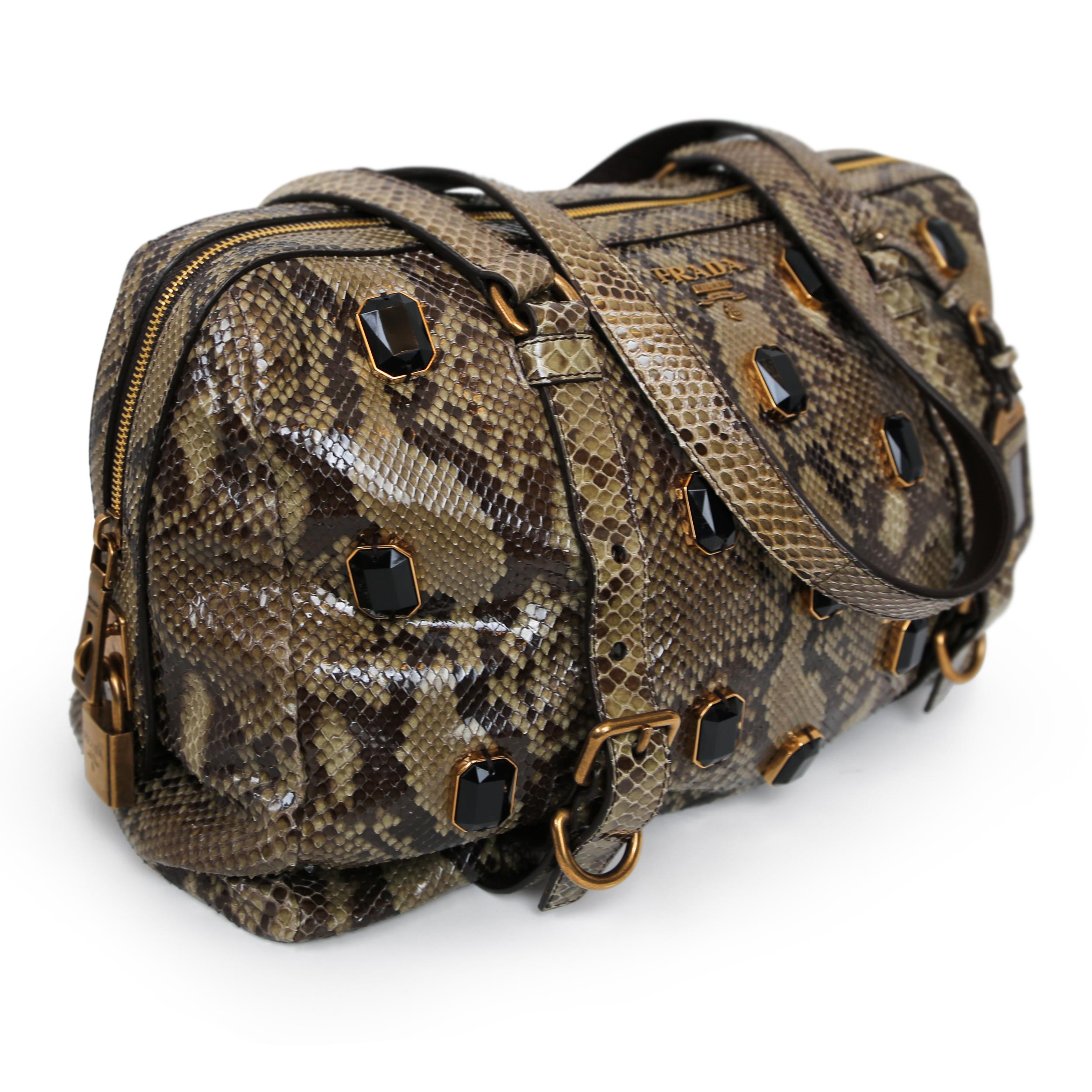 Ce sac exquis de Prada est doté d'un luxueux cuir de python et de ferrures dorées. Le cadenas orné de bijoux et les perles embellies ajoutent une touche de glamour à ce sac à main à bandoulière pratique et polyvalent. Doublé de cuir et doté d'une