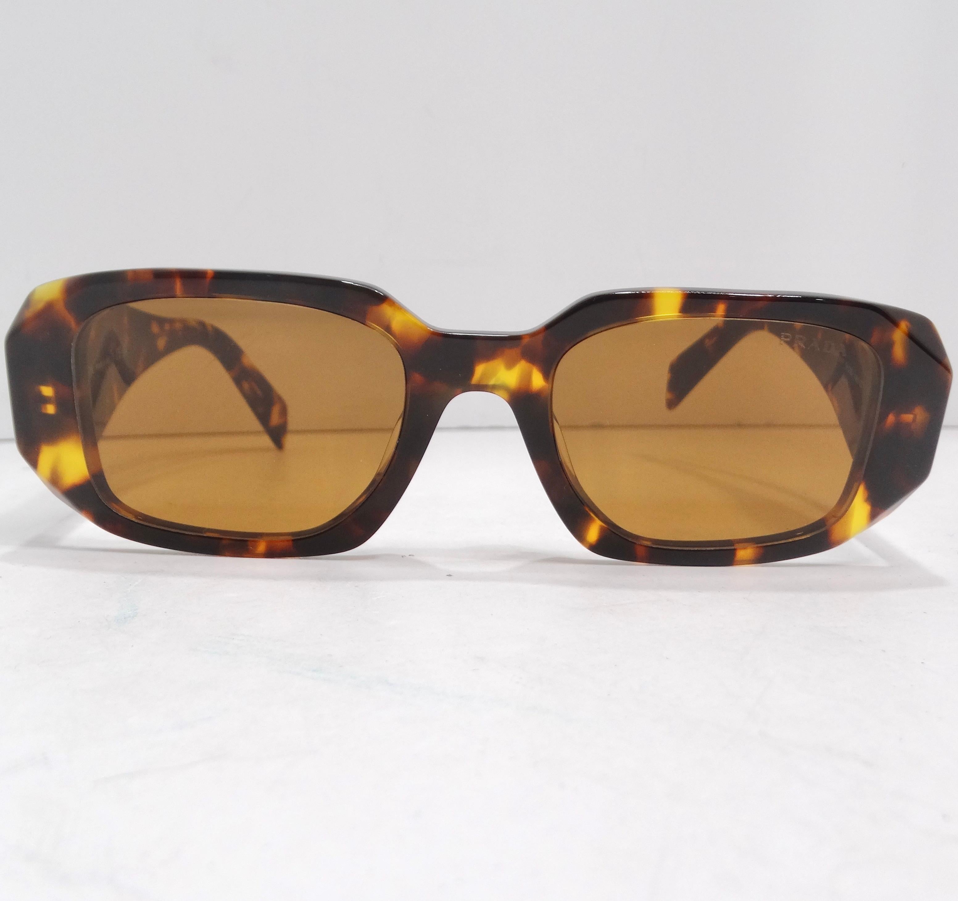 Do not mis out on the Prada Eyewear Tortoise Shell Square Frame Sunglasses – a perfect fusion of sophistication, versatility, and iconic design. These square-frame sunglasses from Prada are not just an accessory; they are a chic and timeless