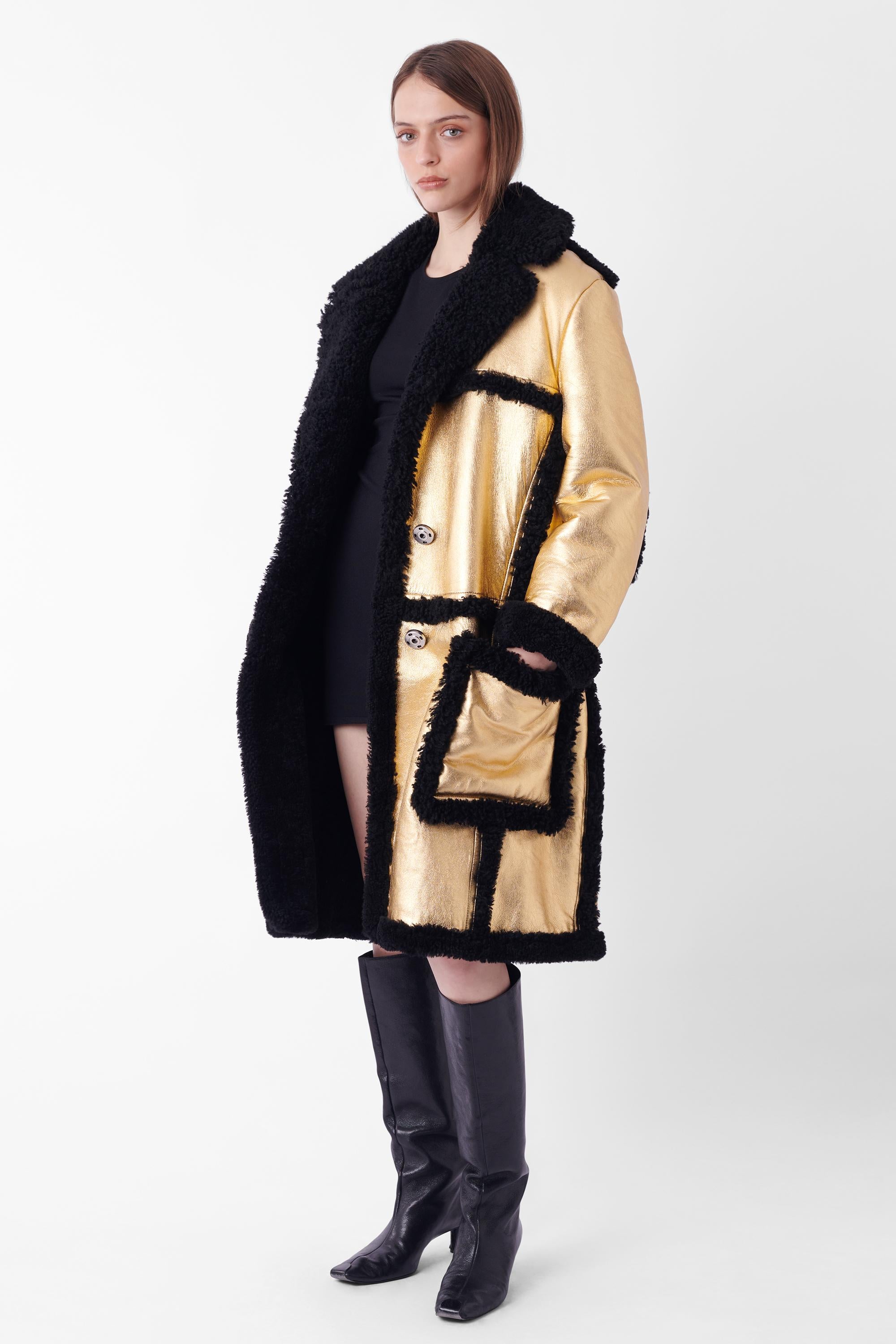 Cappotto Prada Autunno Inverno 2014 in shearling dorato. Presenta un esterno dorato con fodera interna in shearling nero, accenti in shearling, due profonde tasche anteriori e chiusura con bottoni argentati. In ottime condizioni - nuovo di zecca con