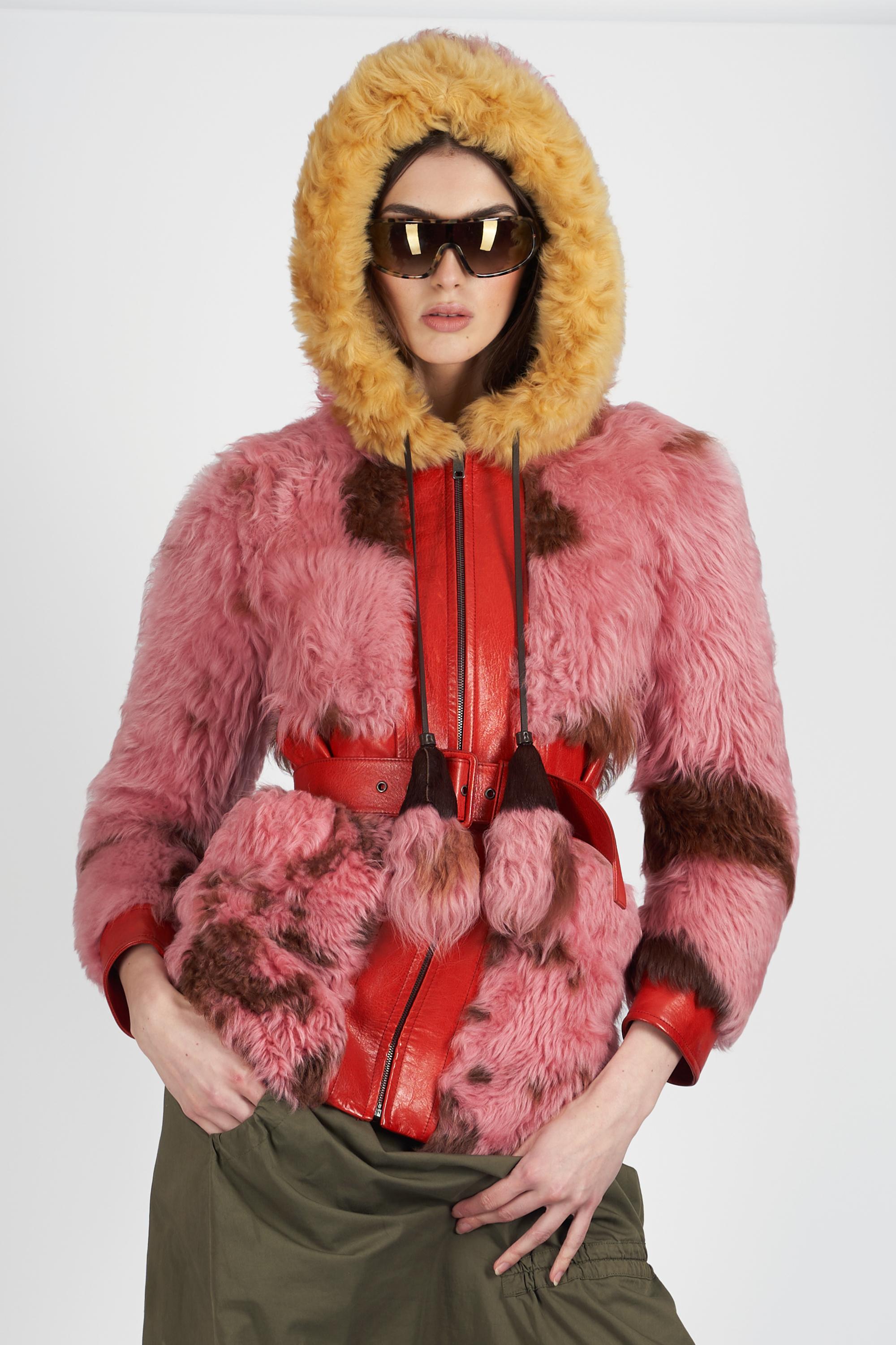 Cappotto con cappuccio in shearling rosa di Prada Autunno Inverno 2017. Presenta tasche, finiture in pelle rossa, cintura e cappuccio con zip frontale. In ottime condizioni vintage, si prega di notare che ci sono alcuni piccoli segni sulla fodera