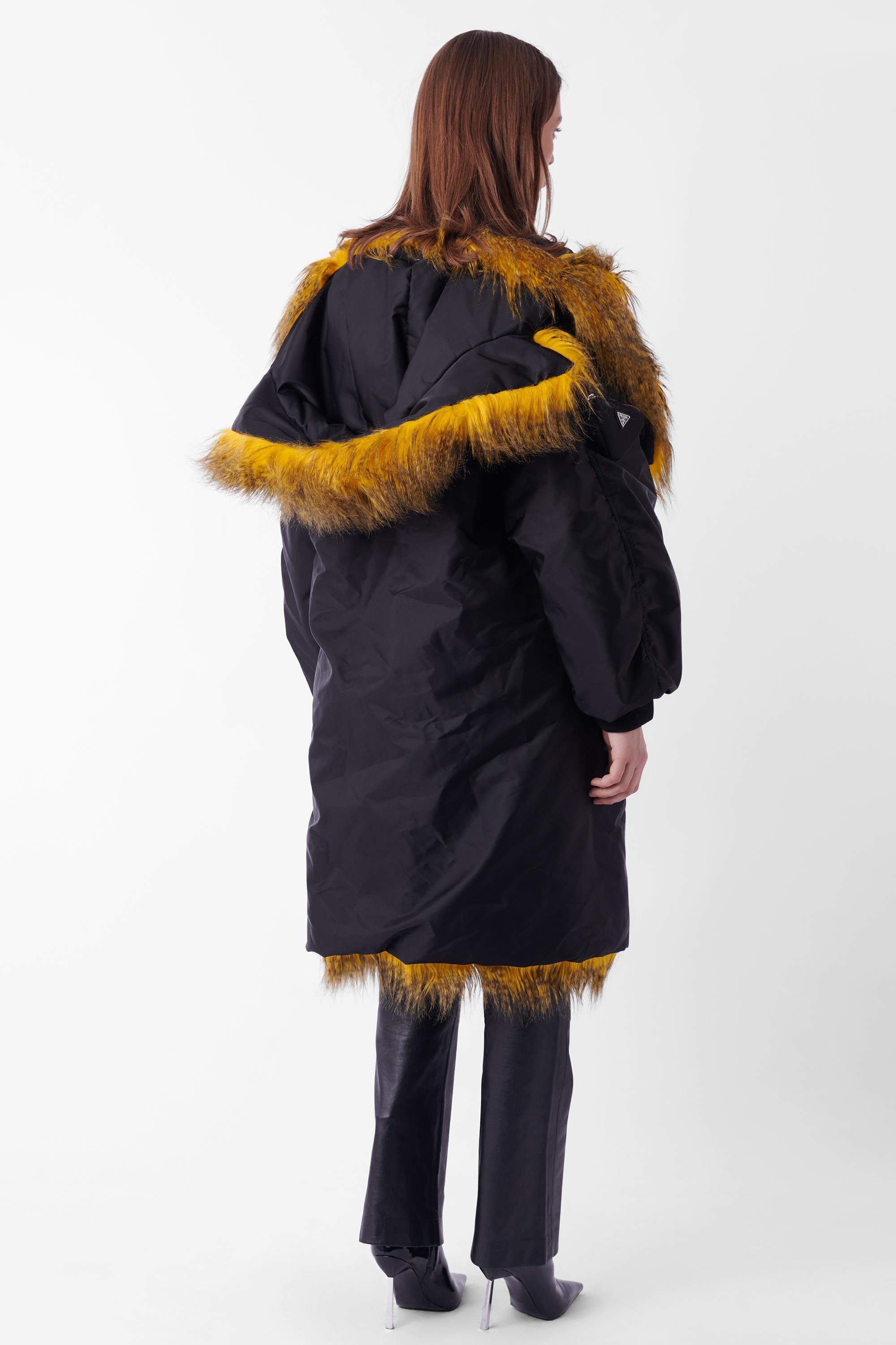 Raf Simmons for Prada Fall Winter 2021 nylon coat, runway look 31. Features black nylon outer shell, black and yellow feather inner, shoulder holds and Prada nylon pocket on arm in oversized fit. In excellent brand new condition. Please note the