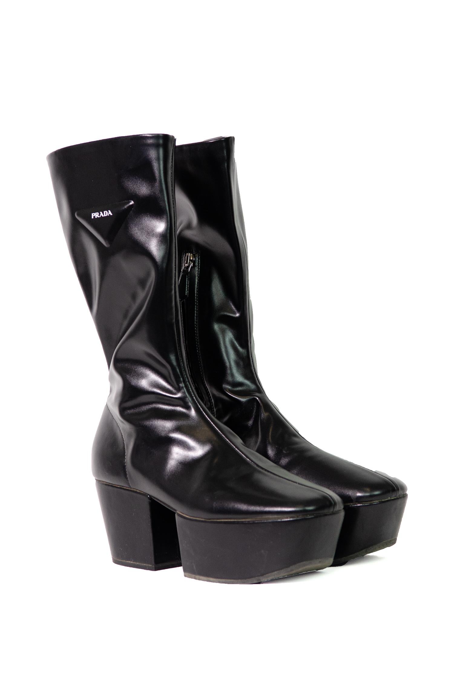 Incredible platform boots from the third collection co-designed by Miuccia Prada and Raf Simmons. This Prada Fall Winter 2021 collection was inspired by the idea of change and transformation.

These sleek ankle length boots are made from a shiny