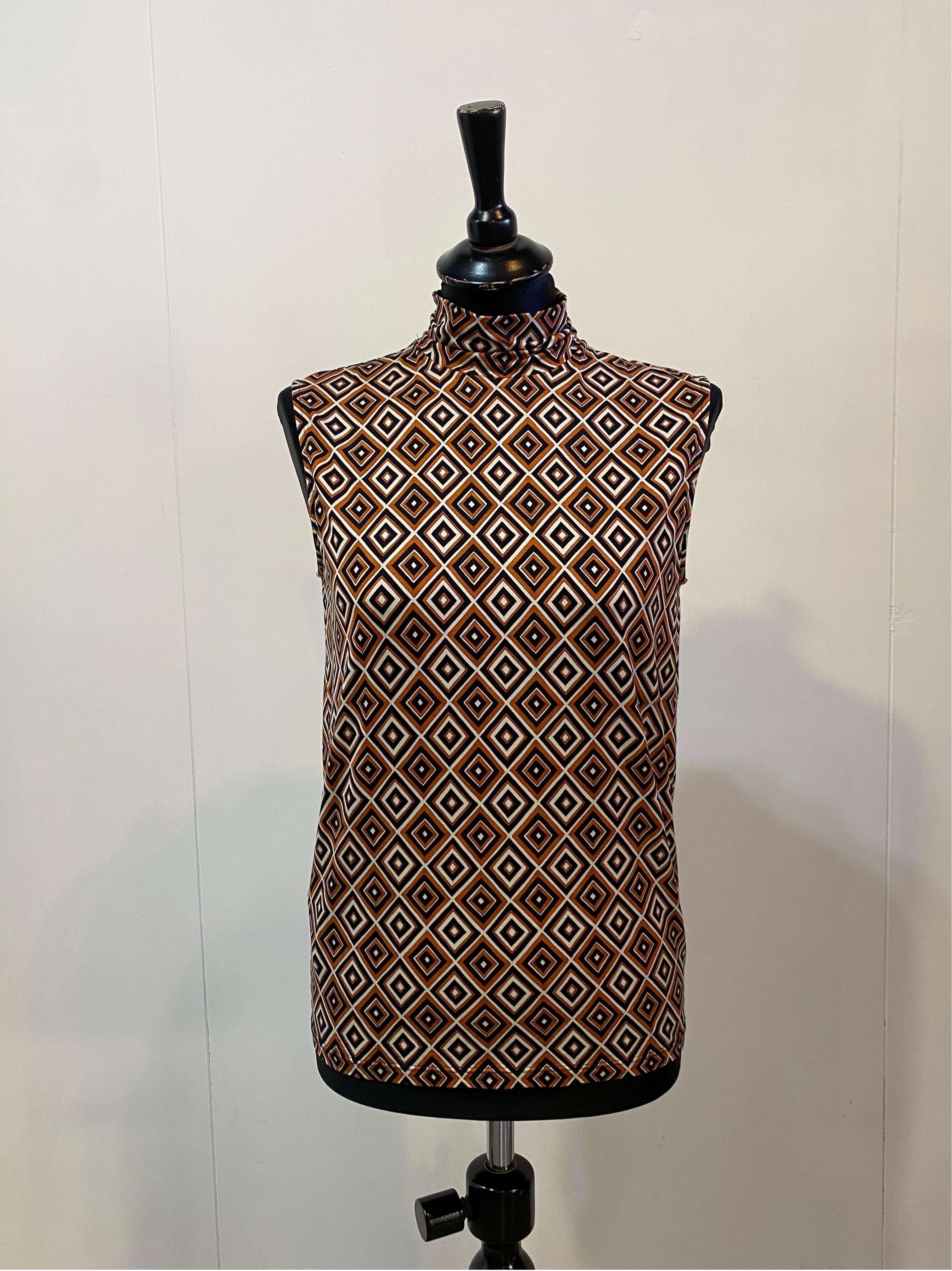 PRADA ENSEMBLE.
Fall 2012 collection.
Sleeveless top + trousers.
60s pattern in shades of orange.
The top is in silk and elastane. Very soft material.
Italian size 42
Bust 44 cm
Length 59 cm
The trousers are made of virgin wool, polyamide and