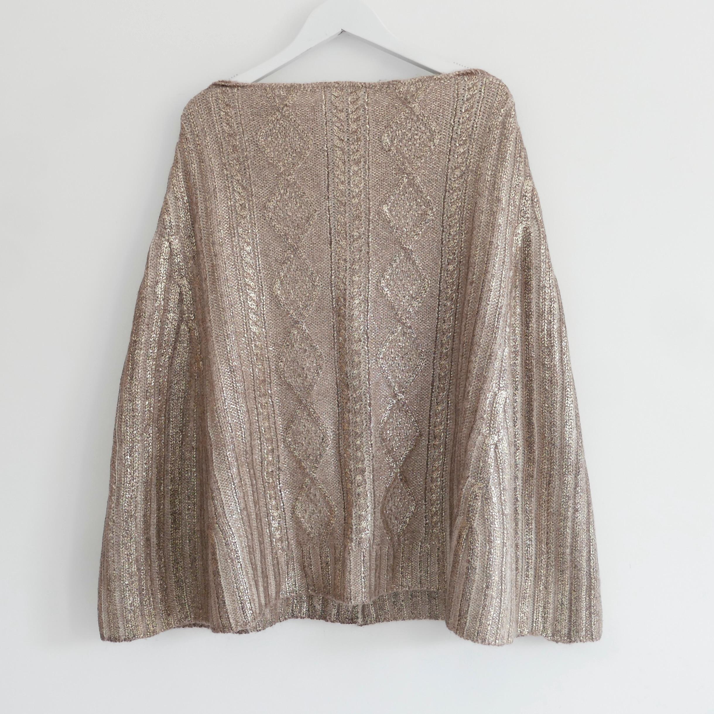 Absolutely gorgeous vintage Prada cape from the Fall 2004 collection. Unworn. Made from soft cable knit alpaca and wool (50:50) with a shimmering gold foil metallic painted covering. It has arm slits to sides and silk covered poppers to front. Size