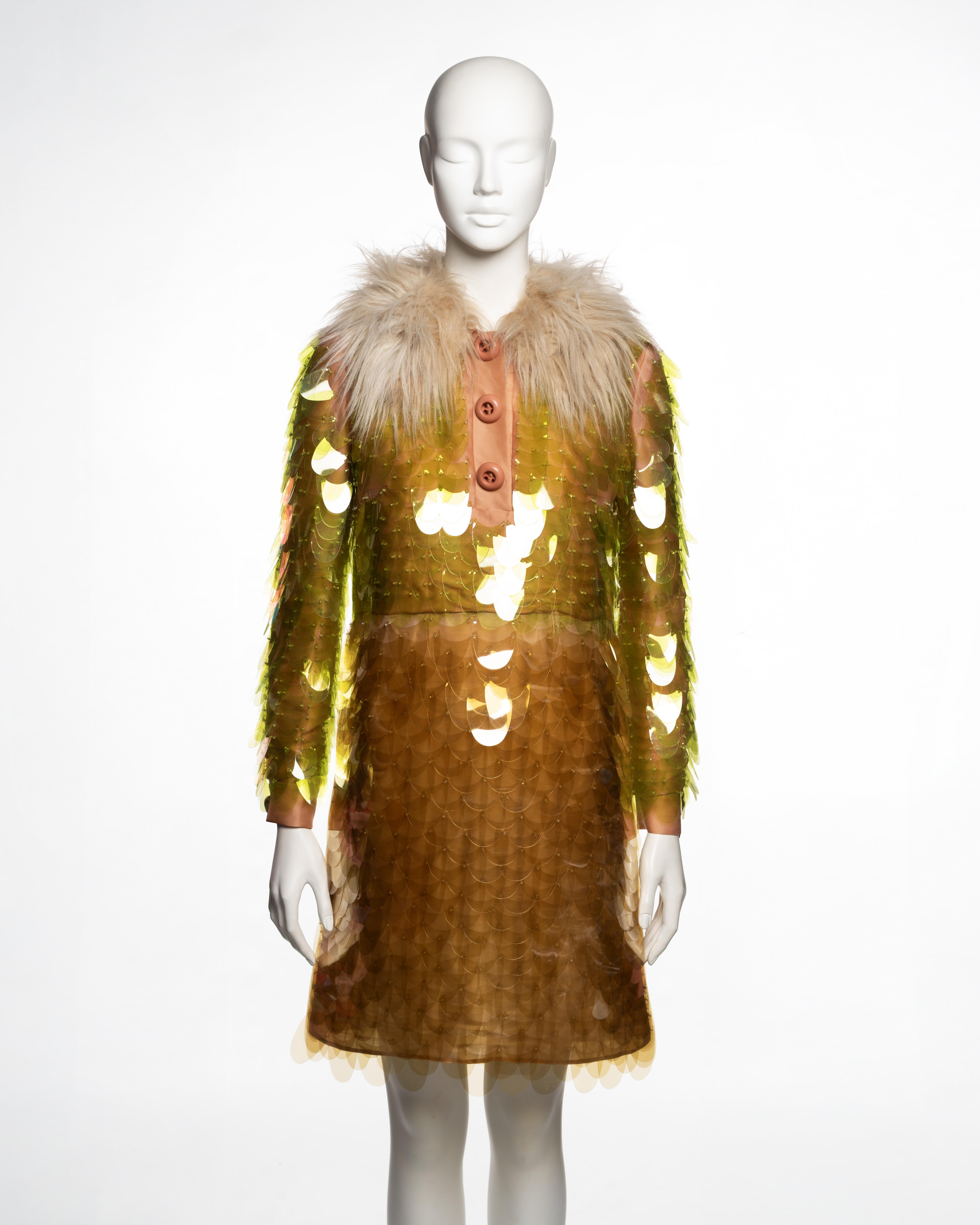 Robe de cocktail de Prada, automne-hiver 2011, réalisée en organza de couleur pêche, brodée sur l'ensemble de pailettes surdimensionnées en plastique translucide cousues en rangs superposés pour former une surface en forme d'écaille. Les pailettes