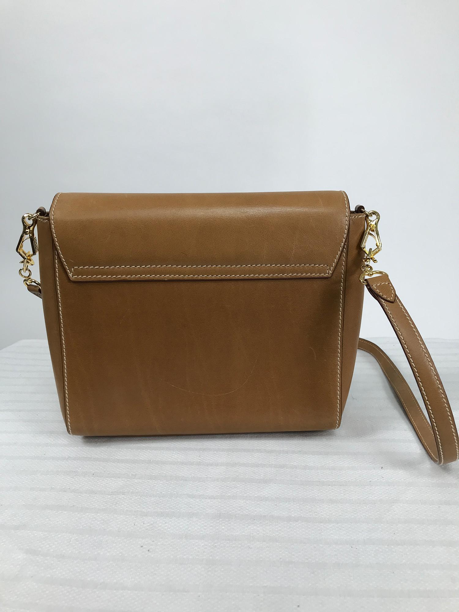 Prada flap front saddle tan leather shoulder bag with gold hardware. Top stitched in off white, the bag has a removable shoulder strap. Closes at the front with a press lock clasp the top marked Prada. The interior has a back zipper compartment,