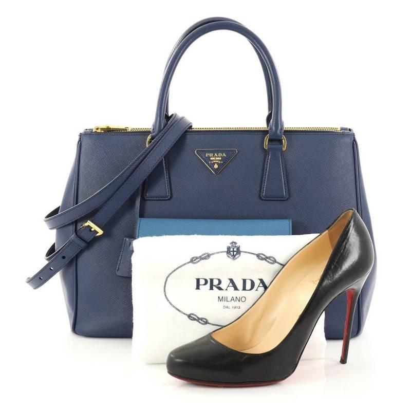 This authentic Prada Front Pocket Double Zip Lux Tote Saffiano Leather Medium is a stylish luxury. Crafted from blue saffiano leather, this boxy tote features side snap buttons, raised Prada logo, dual-rolled leather handles, exterior front pocket