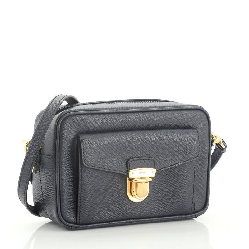 This Prada Front Pocket Zip Crossbody Bag Saffiano Leather Mini, crafted in blue saffiano leather, features an adjustable leather strap, exterior front pocket and gold-tone hardware. Its zip closure opens to a black fabric interior with zip and slip