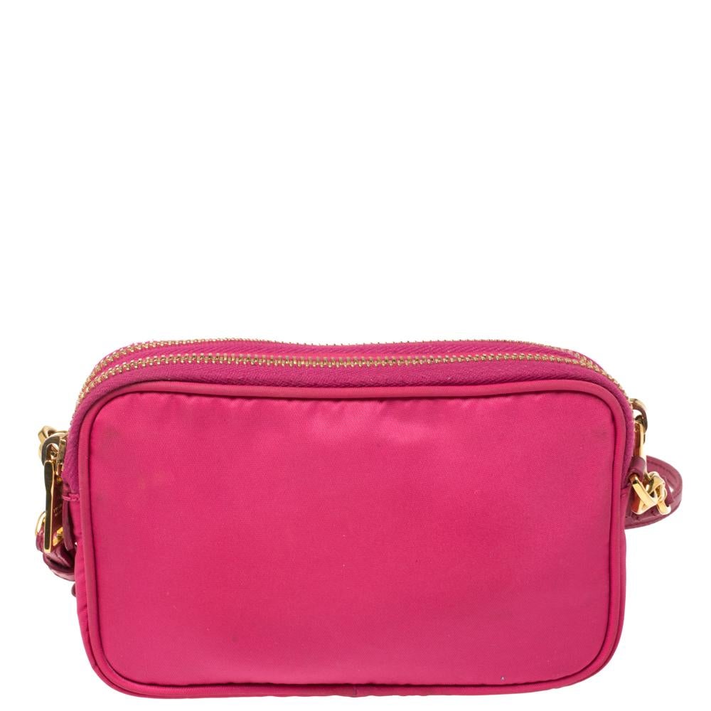 Diese luxuriös gefertigte Crossbody-Tasche von Prada ist in dieser Saison prächtig anzusehen und zur Schau zu stellen. Mit dieser Nylontasche & aus Leder trifft Eleganz mühelos auf Stil. Diese fuchsiafarbene Tasche trägt das Markenlogo auf der