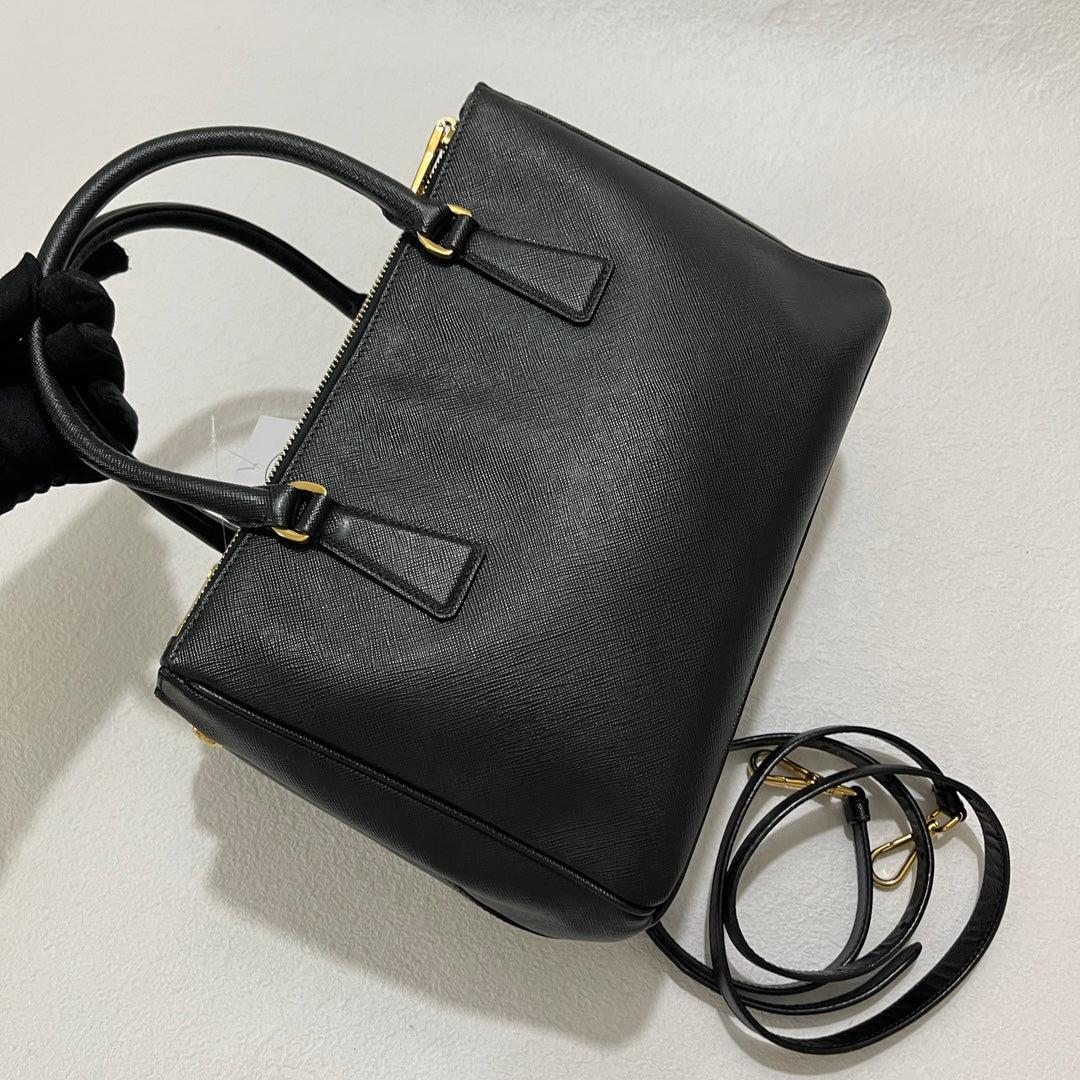 Prada Galleria Saffiano Leather Small Black Handbag with Strap
 These are professional photos of the actual bag.
 Condition: EXCELLENT
 Light cracks on the wax along the edges
 DETAILS
 
 Prada
 Galleria
 Material: Black saffiano calfskin leather
 
