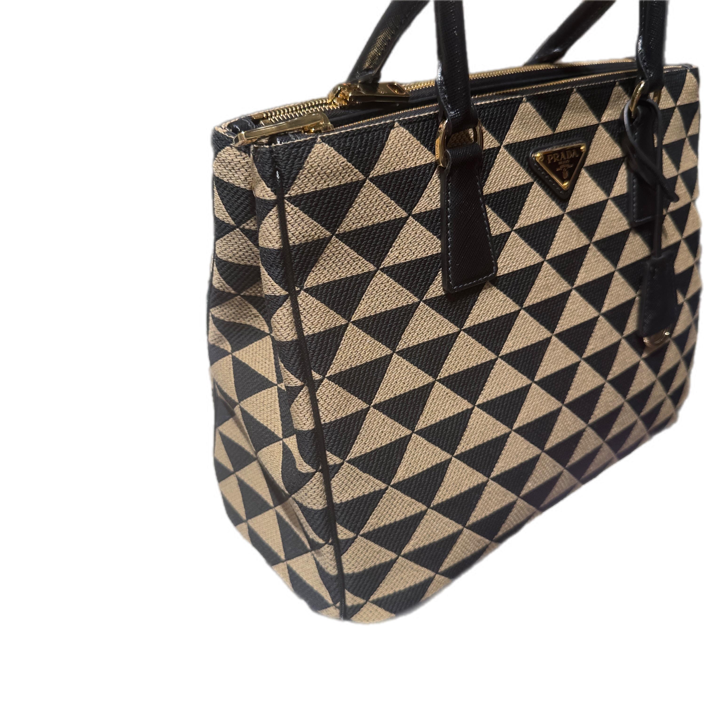 Iconic Prada Galleria geometric jacquard fabric with black Saffiano leather details, removable shoulder strap and excellent condition.
The Prada Galleria is one of the maison's most famous and beloved bags, a symbol of Italian luxury and