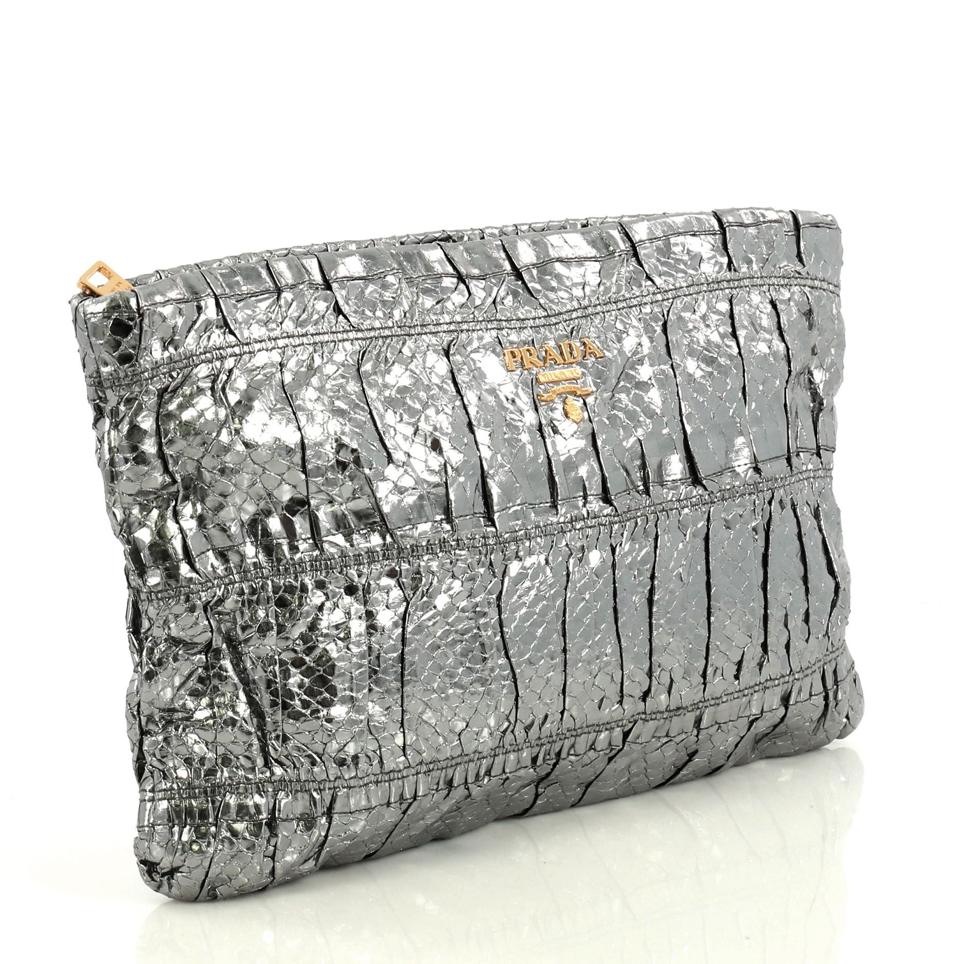 This Prada Gaufre Clutch Python, crafted from genuine metallic silver python, features Prada logo, ruched silhouette and gold-tone hardware. Its zip closure opens to a gray leather interior with side zip pocket. This item can only be shipped within