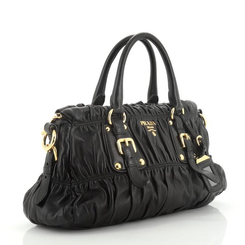 This Prada Gaufre Convertible Satchel Nappa Leather Medium, crafted from black nappa leather, features dual rolled handles, belted details and gold-tone hardware. Its zip closure opens to a black fabric interior. 

Estimated Retail Price: