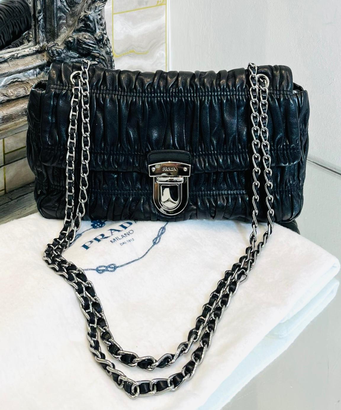 Prada Gaufre Leather Bag

Black bag designed with flap front and 'Prada' engraved clasp closure.

Detailed with soft ruched leather and silver chain and leather entwined shoulder strap.

Featuring ivory leather interior with zipped