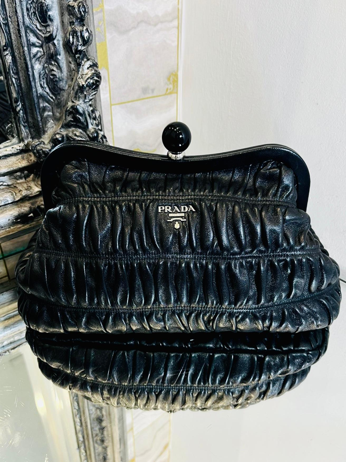 Prada Gaufre Leather Clutch Bag

Black ruched cloud pouch style leather clutch nag with plexi glass ball trim to the top 

of the bag and 'Prada' logo in silver lettering to the front.

Size - Height 18cm, Width 31cm, Depth 10cm

Condition - Very