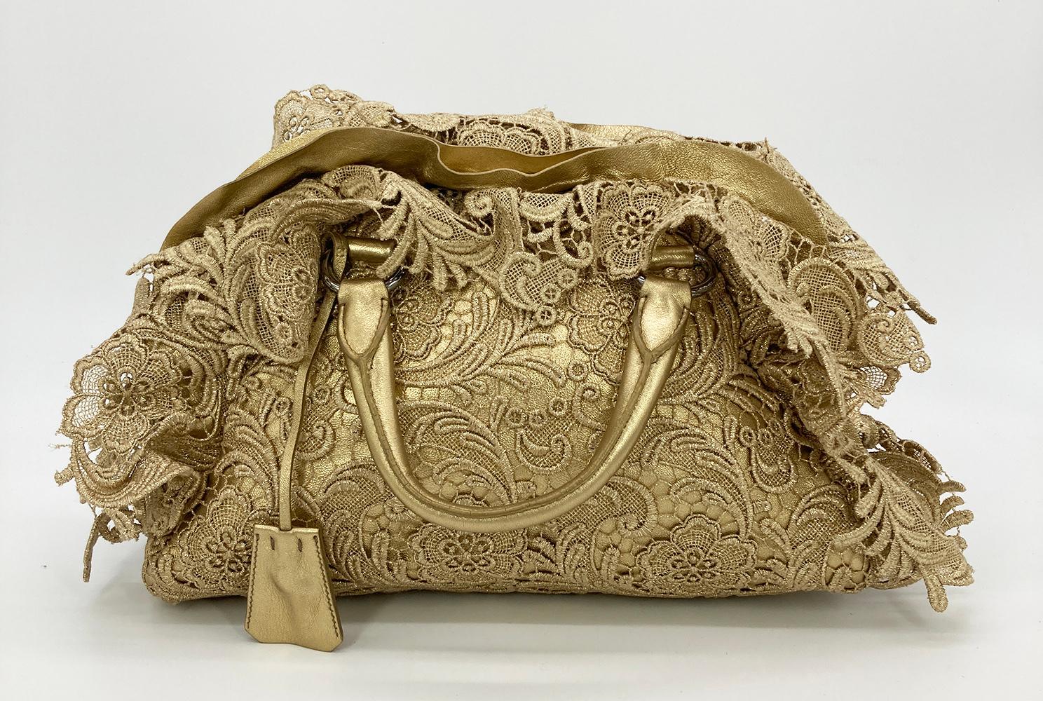 Prada Gold Leather and Lace Pizzo bag in excellent condition. Gold leather body with a gold lace overlay, gold leather trim details, and silver hardware. Top full zipper closure opens to a black nylon interior with one slit and one zipped side