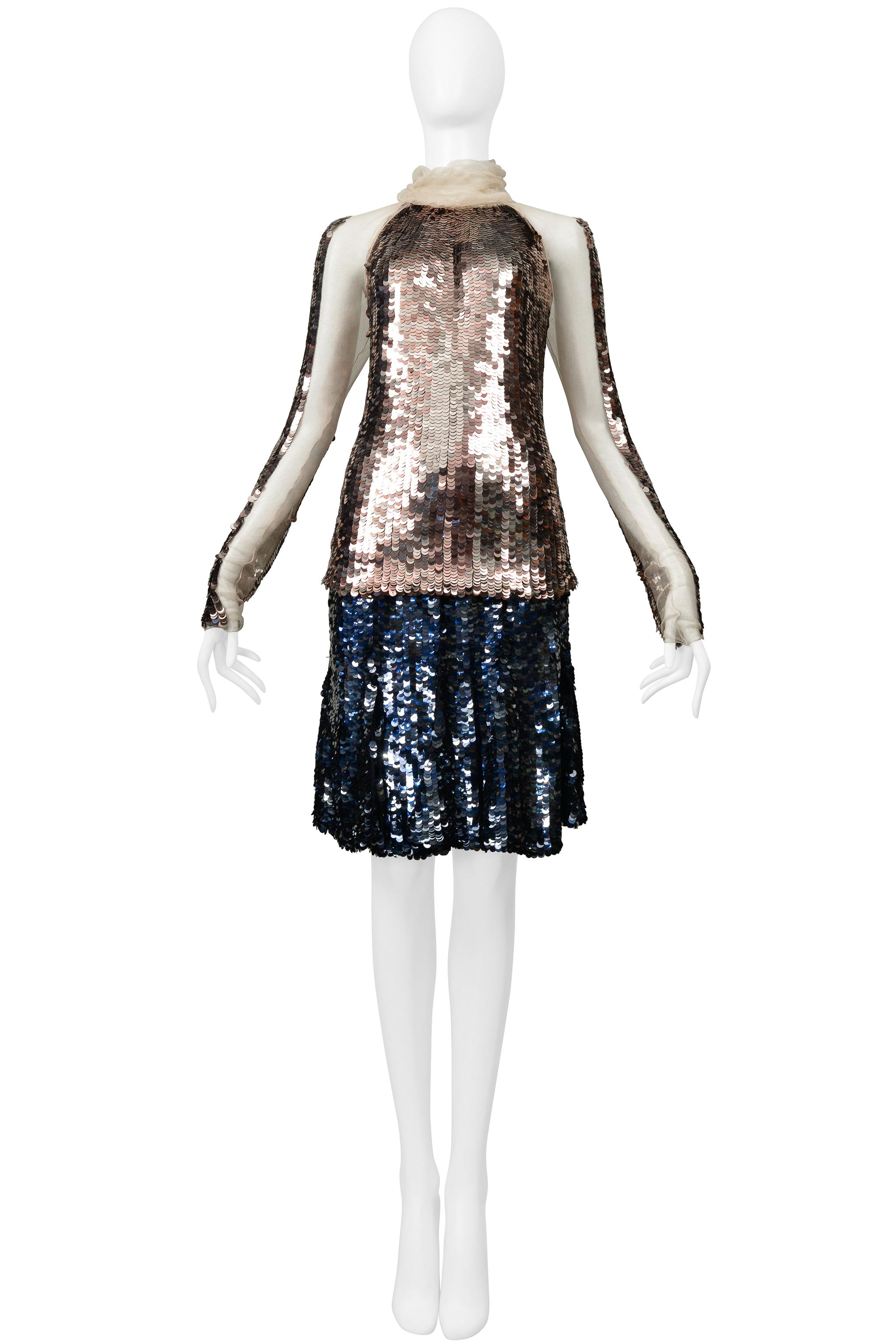 Resurrection Vintage is excited to offer a vintage Prada gold & navy metallic round paillette skirt ensemble from the 2002 collection. This iconic ensemble features a metallic top and navy skirt, mix of silver and bronze sequins, long sheer sleeves,