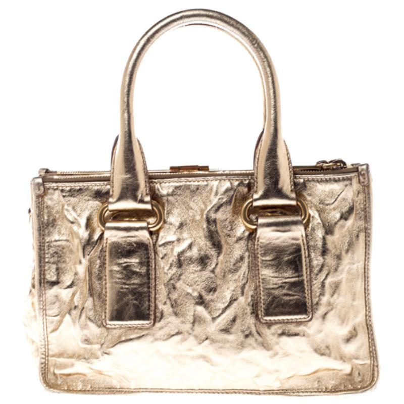 Feminine in shape and grand in design, this Double Zip tote by Prada will be a loved addition to your closet. It has been crafted from patent leather and styled with gold-one hardware. It comes with two top handles, two zip compartments and a