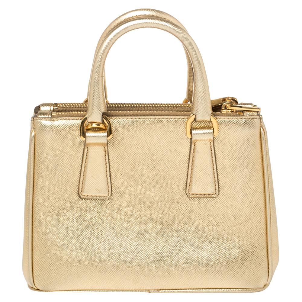 Loved for its classic appeal and functional design, Galleria is one of the most iconic bags from the house of Prada. This beauty in gold is crafted from Saffiano Lux leather and is equipped with two top handles, the brand logo at the front, and a
