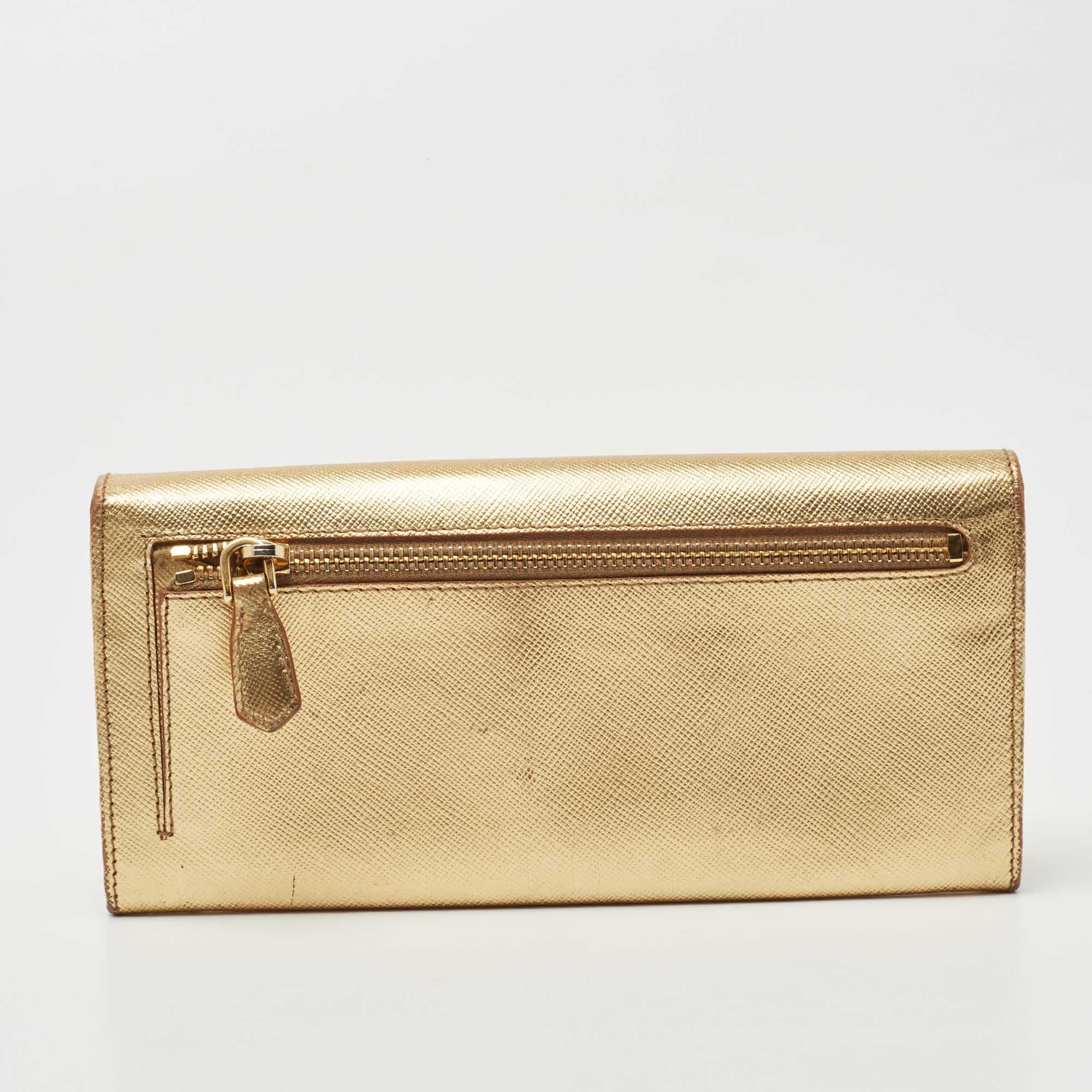 This continental wallet from Prada is a must-have fashionable accessory. With its classy exterior and practical shape, this wallet functions as more than just a stylish carry-on. It is made with beige Saffiano Lux leather and has a gold-toned logo
