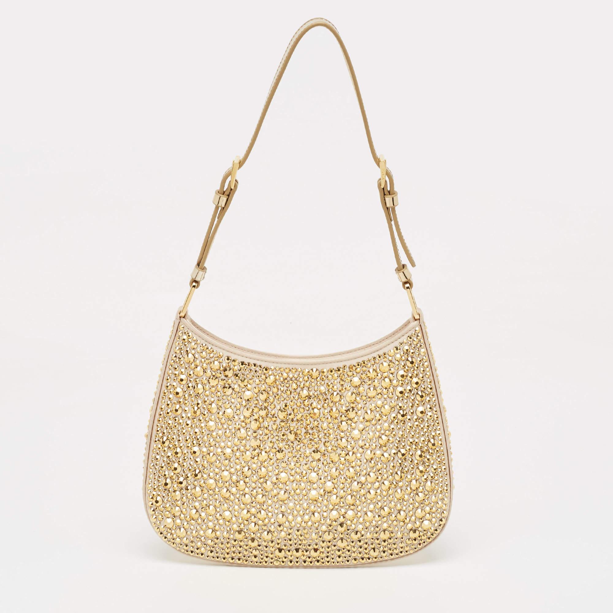 The Prada Cleo Shoulder Bag exudes elegance with its lustrous gold satin exterior adorned with dazzling crystal embellishments. Its sleek silhouette and compact size make it perfect for evening affairs, while the chain strap adds a touch of