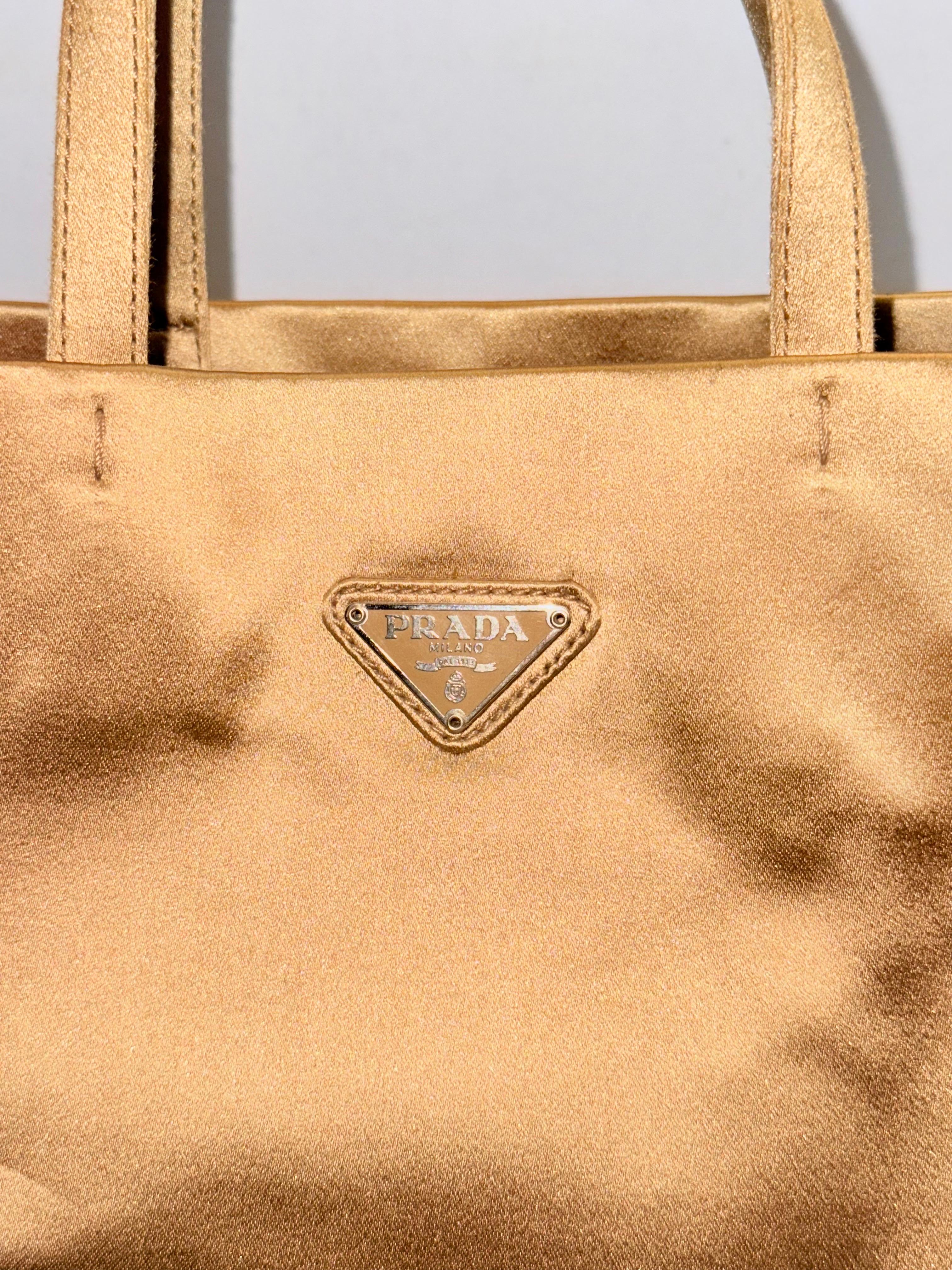 - Vintage Prada gold silk satin small rectangle shape handbag. Always chic and timeless.

- Measurements: 
Length: 9 inches. 
Width : 3 inches.
Height:  10 inches. 
Handle Drop: 4.5 inches. 

- Prada lining. 

- One interior zip pocket closure. 

 -