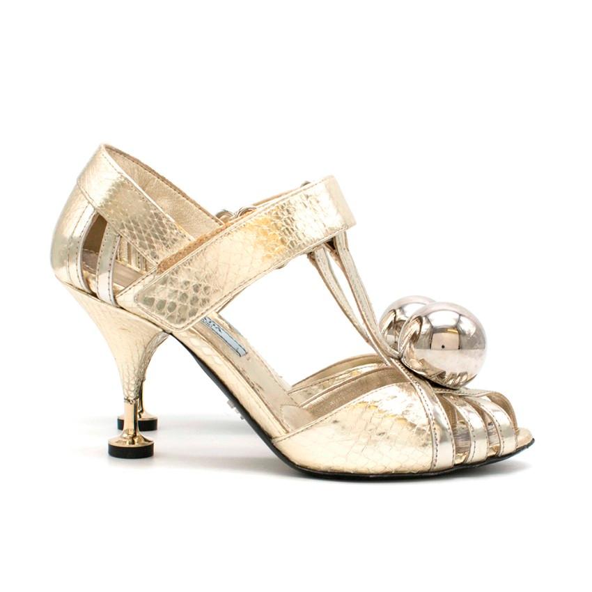 Prada Gold Snake Kitten Heels

- Patient Gold snake print leather
- T-Strap with velcro closure
- Open toe with multiple straps
- Large gold ball detail on the toe
- Kitten heel with black stopper
- Exposed multi-strap detailing

Materials