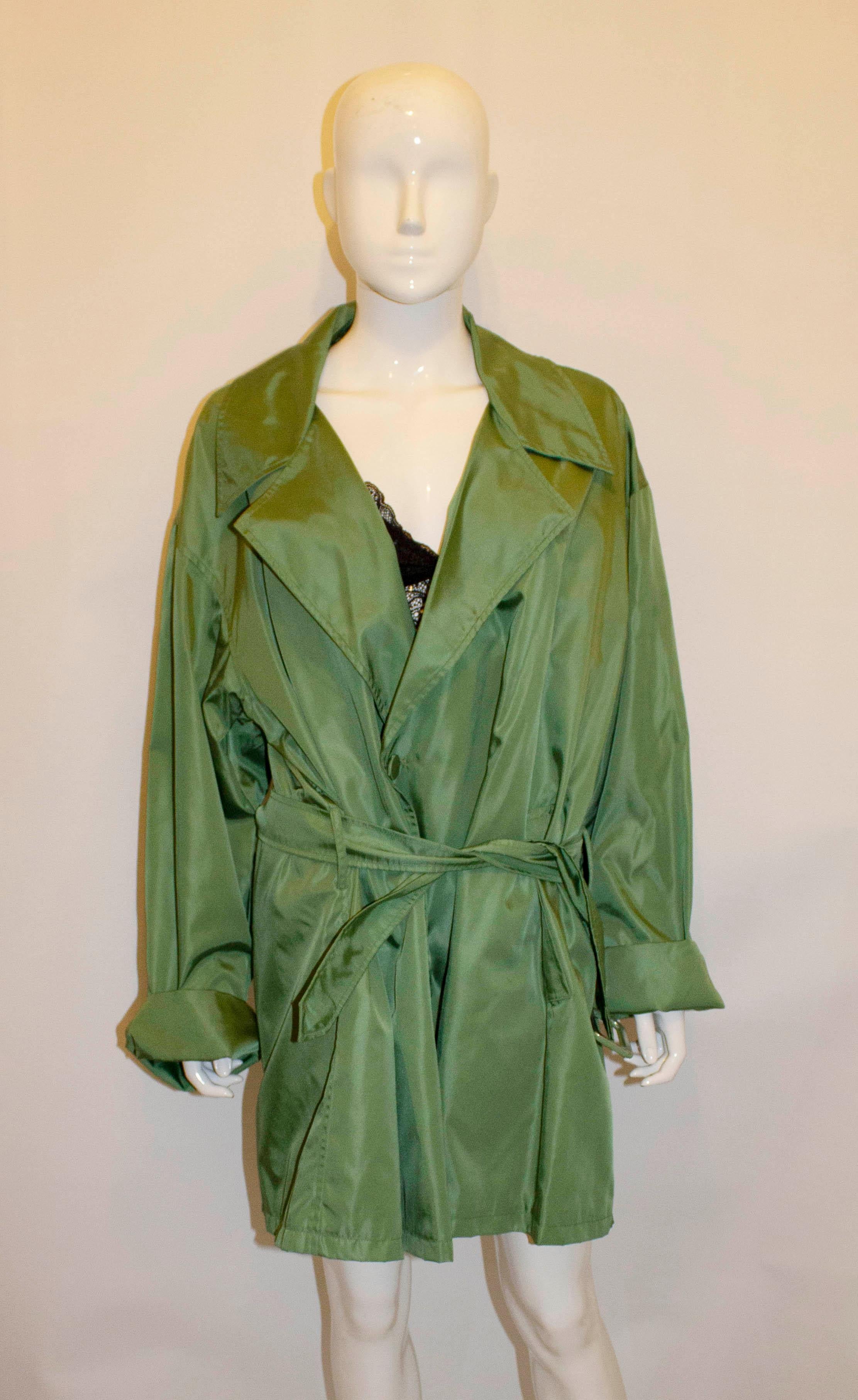 A head turning coat by Prada. In a wonderful grass green colour, the coat has turn back cuffs and  a self fabric belt . It is fully lined, and has never been worn. Size S, and will fit bust up to 46'', but looks better worn loose, length 34''