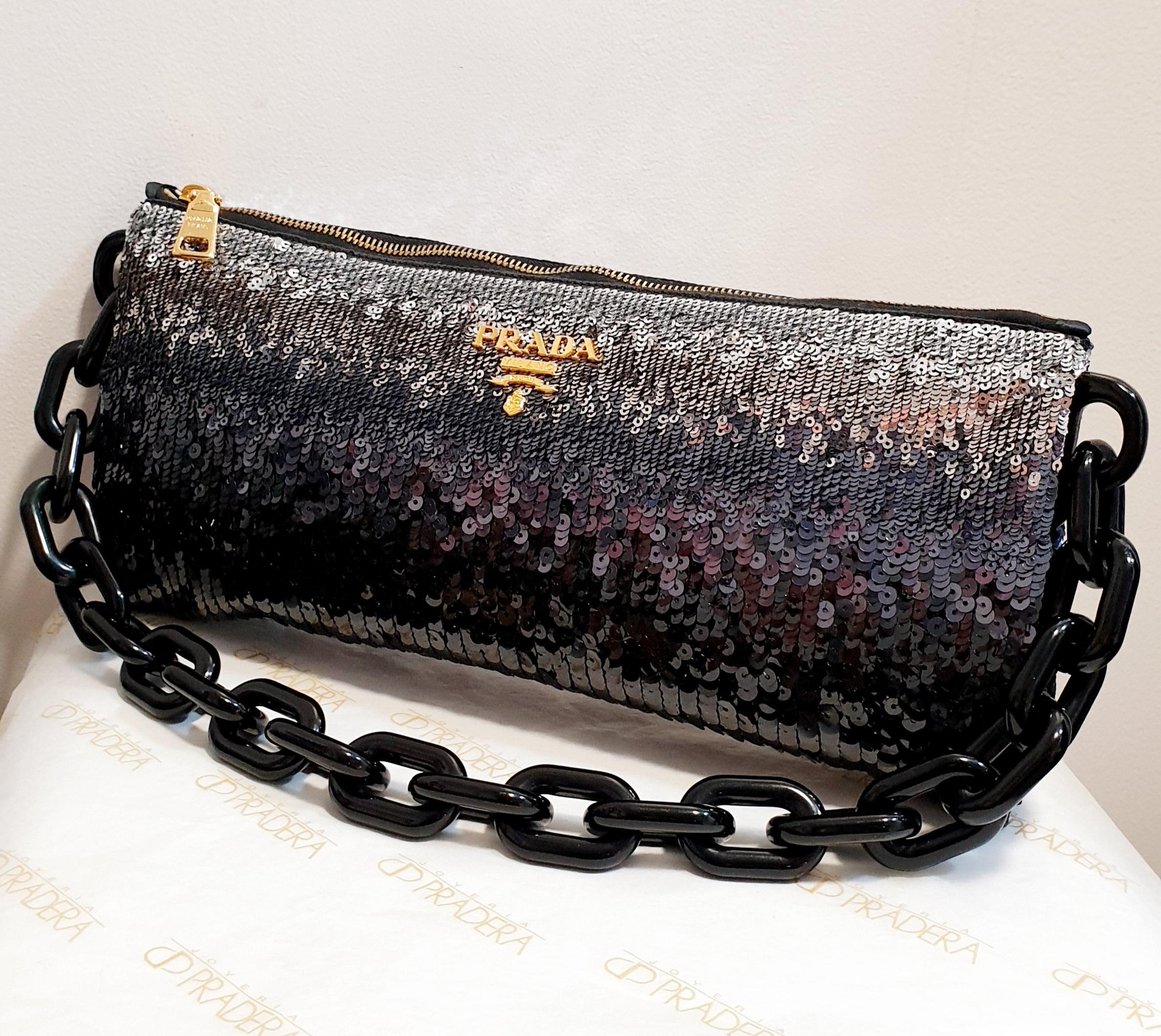 Prada Gray black sequin baguette
This baguette features a sequined satin, resin chain, and a top zipper closure. 
Rest of boutique stock
New Never used
Original bag
Dimensions:
Length: 14 cm  5,51 inches
Width: 31 cm  12,20 inches
Depth: 4 cm  1,57