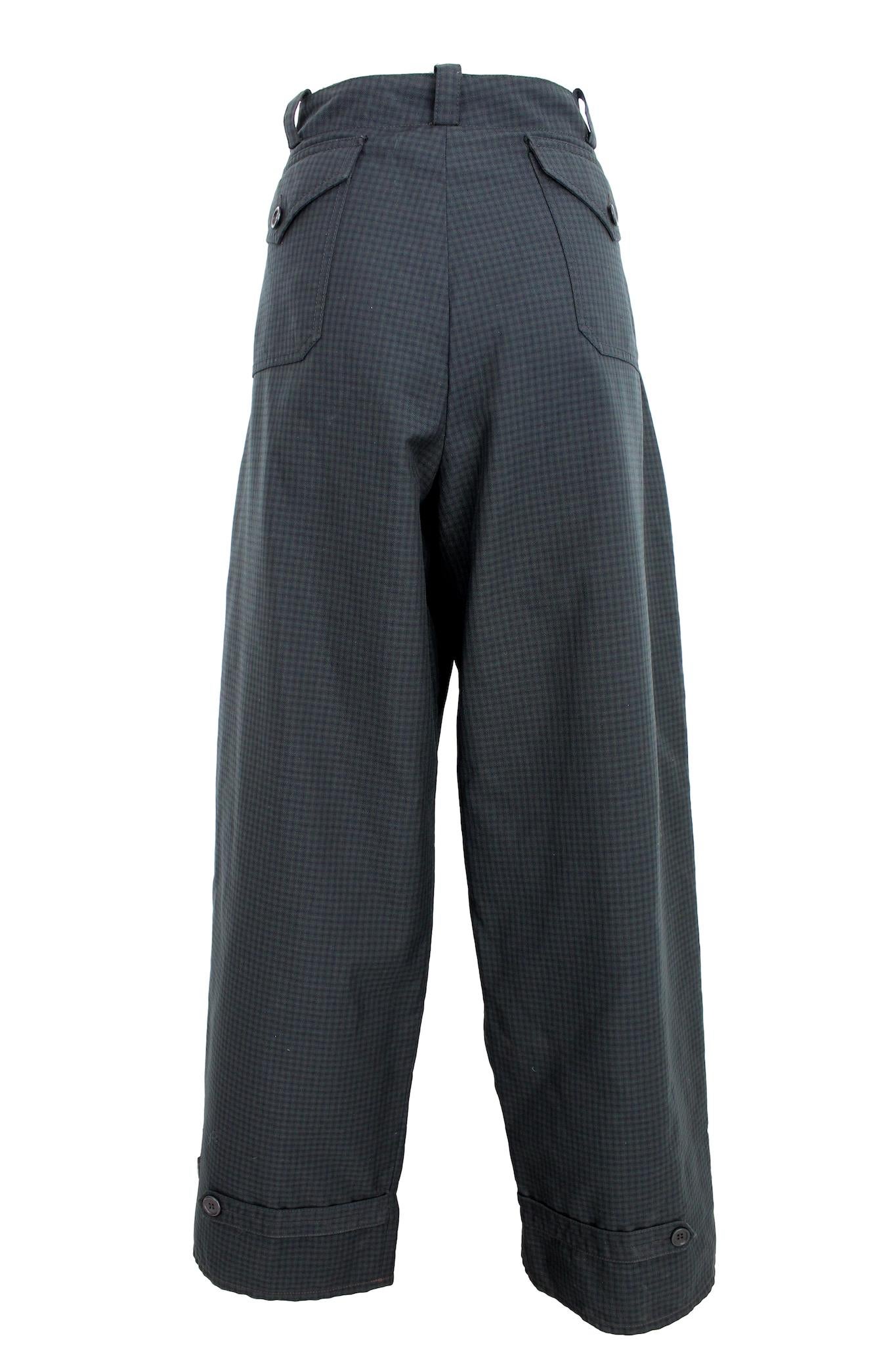 Ce pantalon vintage 90s de Prada est un complément élégant à toute garde-robe. Le pantalon cargo présente une coupe ample, confortable et tendance. Le motif à carreaux vert et gris ajoute une touche de personnalité et de flair à la tenue, tandis que