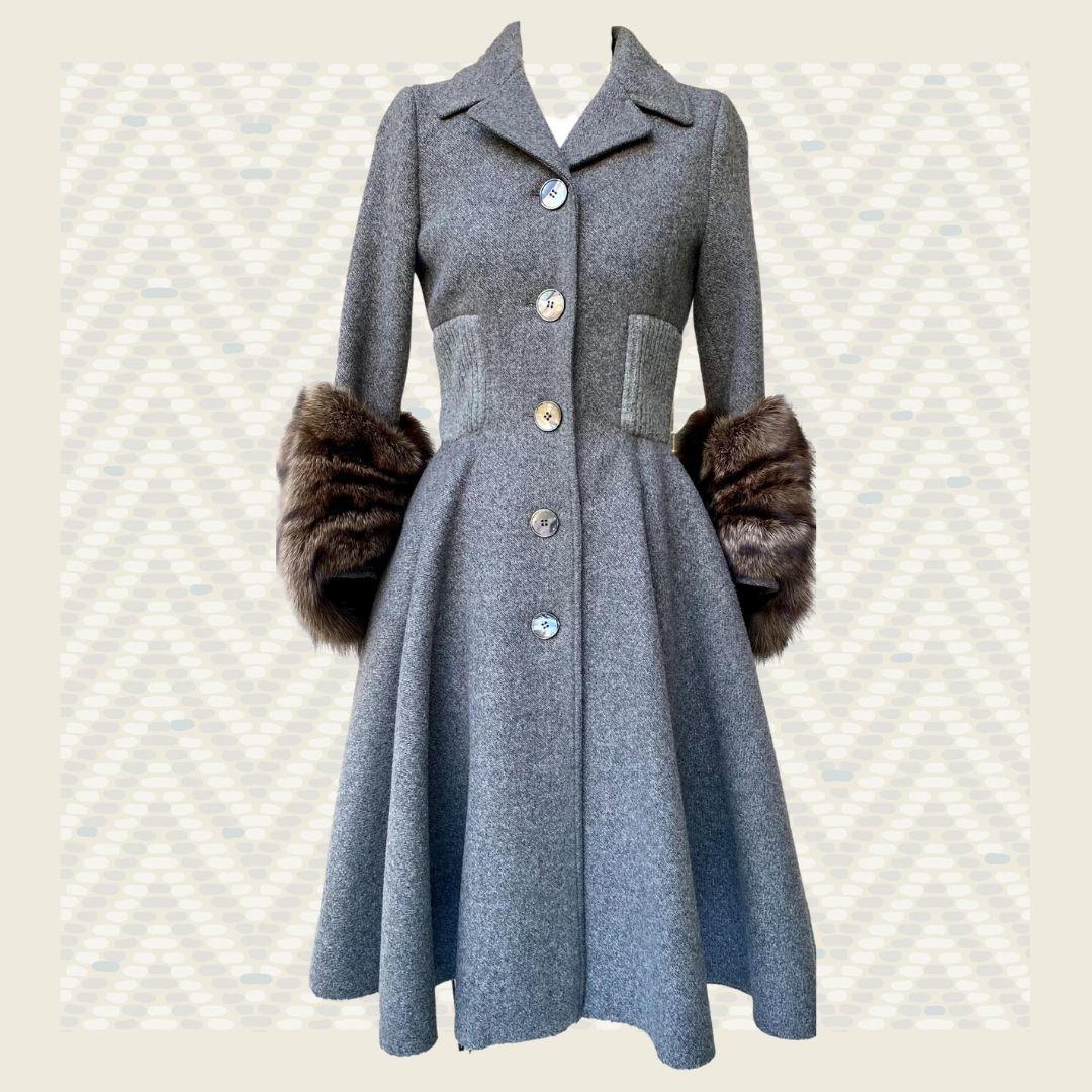 Prada - Strikingly elegant gray runway coat with large mink fur cuffs.  This coat is fitted at the waistline with gray ribbed stretchy fabric and has a large full circle, flared hemline. Front button closure.  Very reminiscent of an Audrey Hepburn