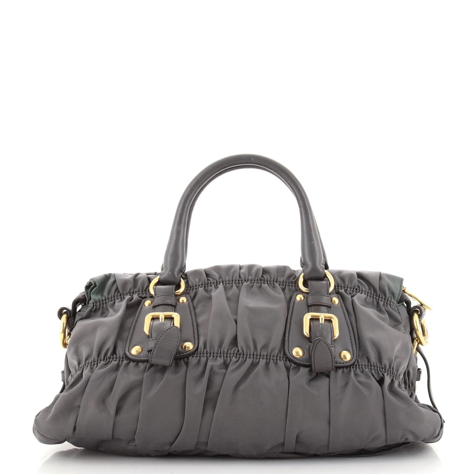 Prada Gray Tessuto Nylon Gaufre Convertible Medium Satchel Tasche

Details zum Zustand: Knicke an der Außenseite, mäßige Verfärbungen an den Öffnungs- und Bodenkanten. Flecken auf den Lederbesätzen und der Innenöffnung, Verkrümmungen an den Griffen,