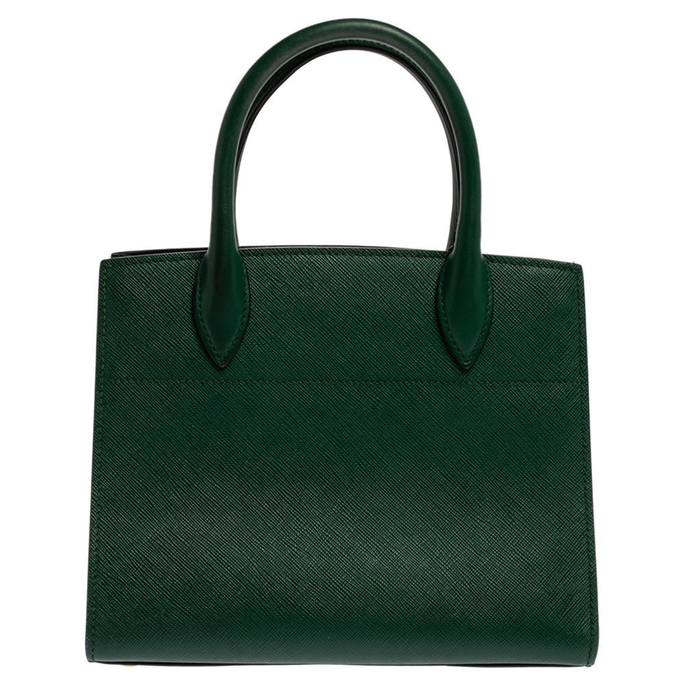 Feminine and stylish, this Bibliotheque mini tote from Prada is a worthy buy. Crafted from green & black leather, the bag features dual top handles, a removable shoulder strap and protective metal feet at the bottom. The leather-lined interior is