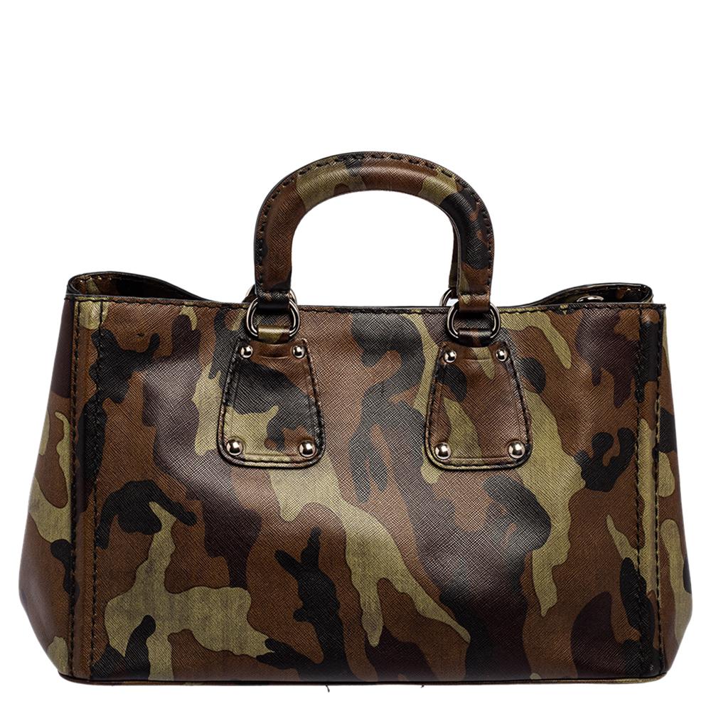 Crafted with camouflage leather, this Prada shopper tote has silver-tone hardware, top handles, and a removable shoulder strap. It has a spacious interior with a zipped pocket to hold all your essentials. Four protective feet have been placed at the