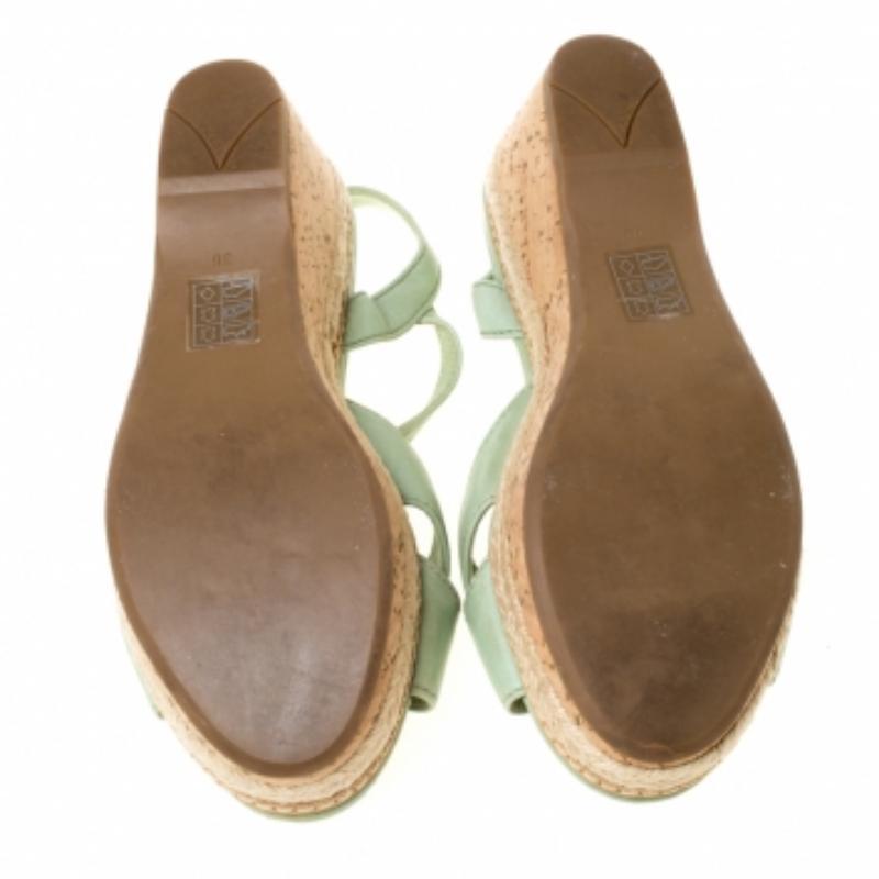 Cette paire de sandales espadrilles vertes de Prada est ravissante. Elles ont été merveilleusement confectionnées en cuir et sont dotées de brides de cheville et de semelles compensées en liège avec des détails d'espadrille. Complétée par des