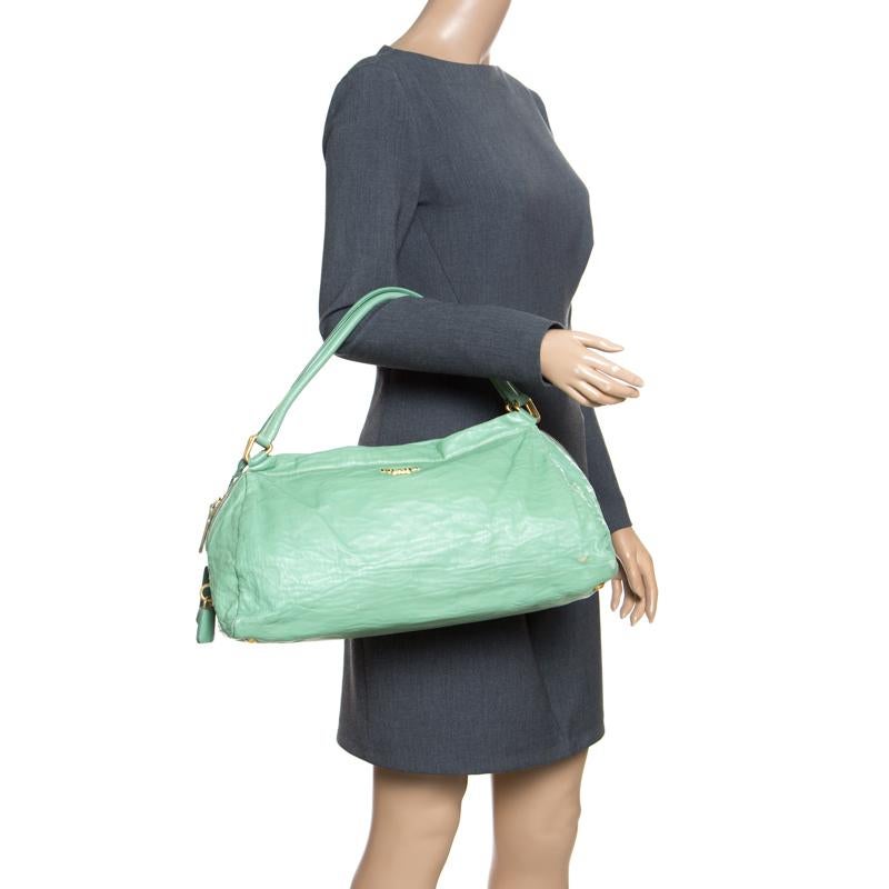 This Bowler bag from Prada is simple in design but highly functional. Crafted from green leather, the bag features two handles and protective feet at the bottom. It has the brand name detailed on the front and a top zipper reveals a nylon interior