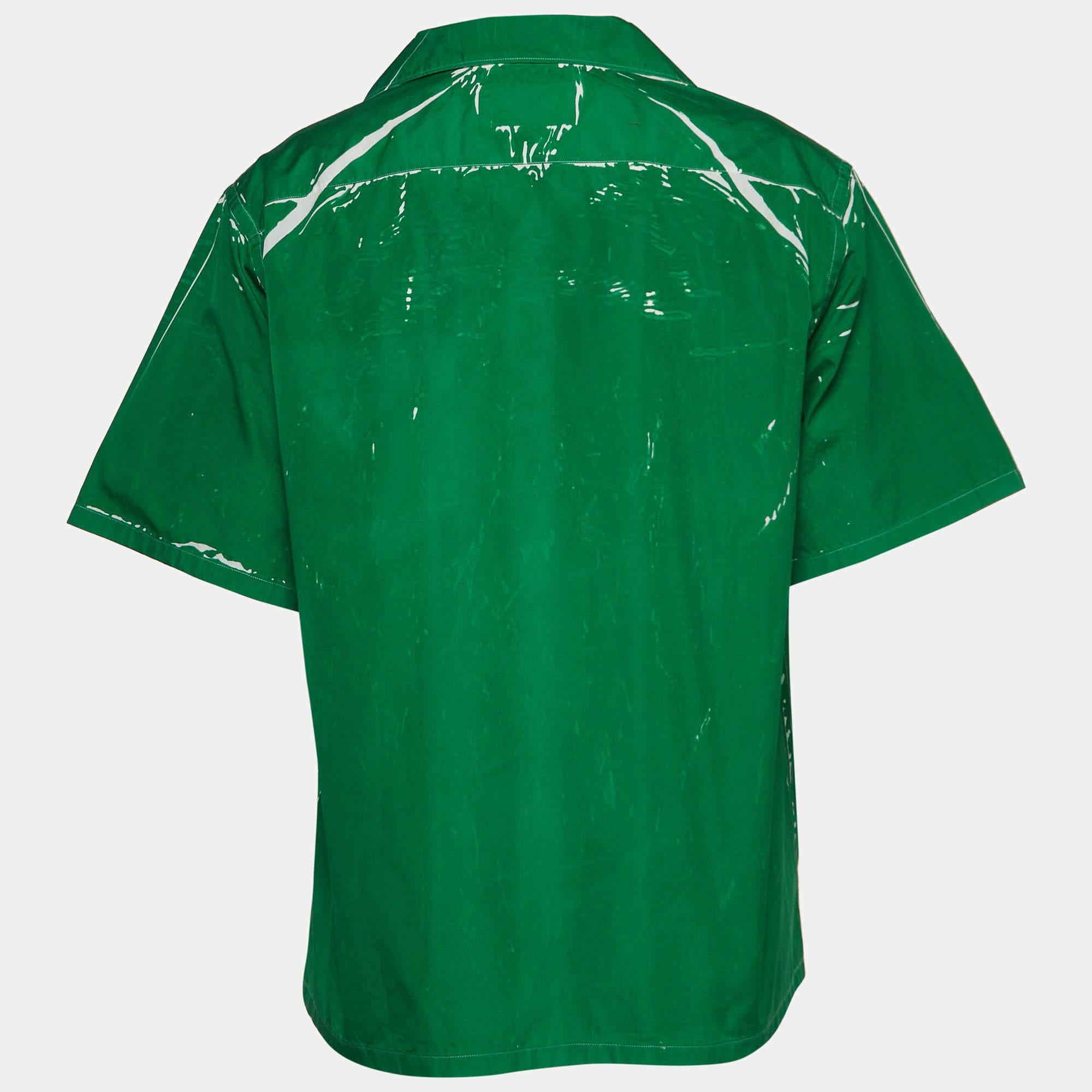 The Prada bowling shirt epitomizes casual elegance. Crafted from premium cotton, it features a vibrant green hue adorned with subtle prints. The relaxed bowling shirt silhouette is complemented by a button-down front, short sleeves, and a