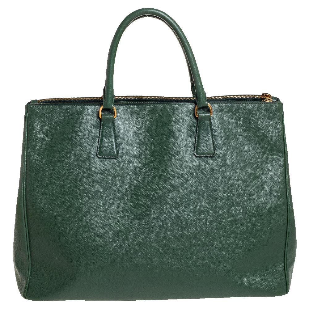 Feminine in shape and grand in design, this Executive Double Zip tote by Prada will be a loved addition to your closet. It has been crafted from leather and styled minimally with gold-tone hardware. It comes with two top handles, two zip