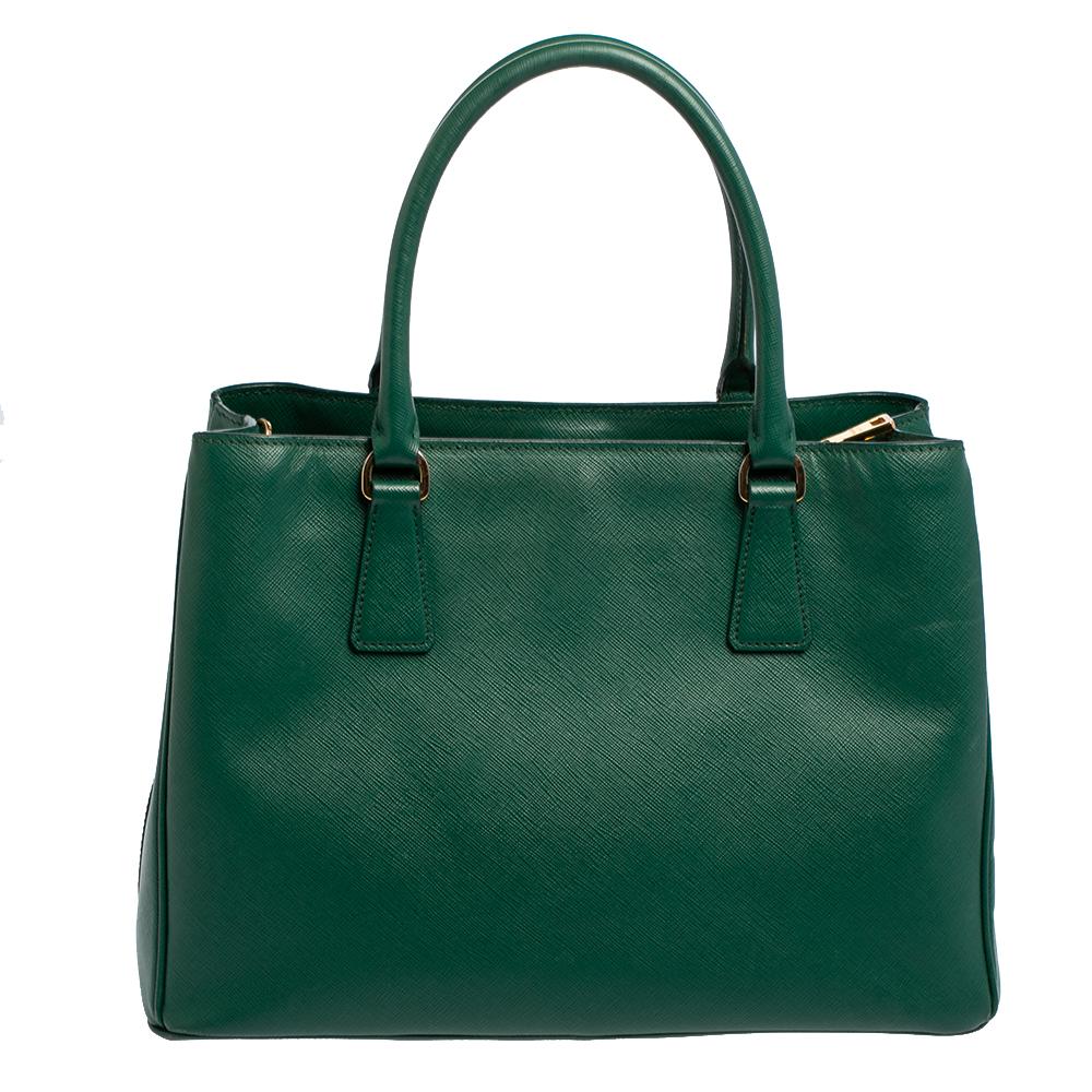 Loved for its classic appeal and functional design, Galleria is one of the most iconic and popular bags from the house of Prada. This beauty in green is crafted from Saffiano Lux leather and is equipped with two top handles, the brand logo at the