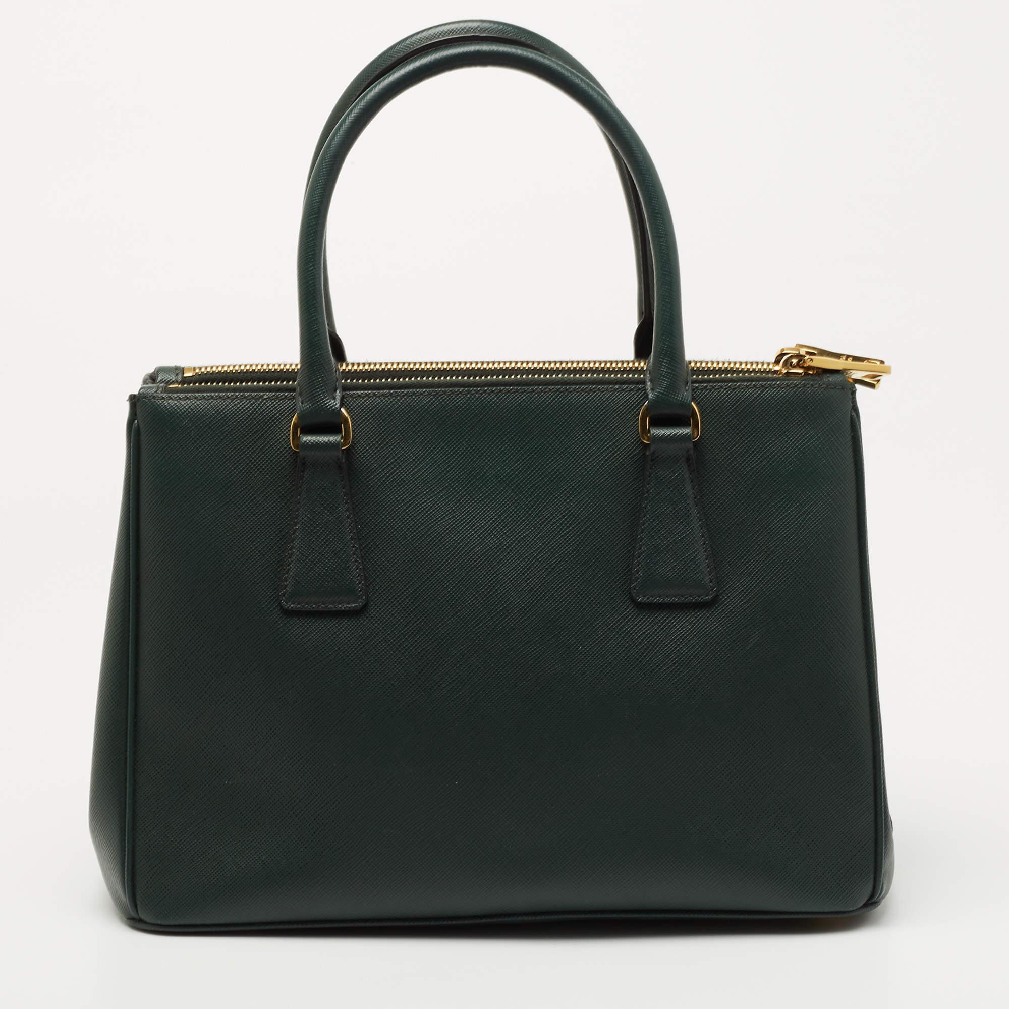 This Double-Zip Galleria tote by Prada will be a loved addition to your closet. It has been crafted from Saffiano Lux leather and styled minimally with gold-tone hardware. It comes with two top handles, two zip compartments, and a perfectly-sized