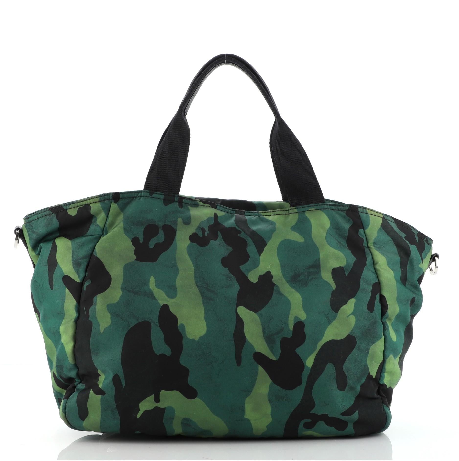 Prada Green Tessuto Print Camouflage Convertible Large Pocket Tote Bag features green Tessuto nylon camouflage print with one external zipped pocket, two black canvas handle covered by black leather, black fabric lining and silver-tone hardware. 

