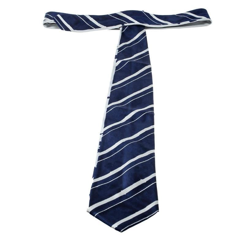 Pick this Prada tie to add a touch of grace to your corporate outfits. Made from silk, the tie sports a deep blue hue decked with grey coloured stripes. The filling length and the supporting keeper loop makes this one an effortless piece of fashion