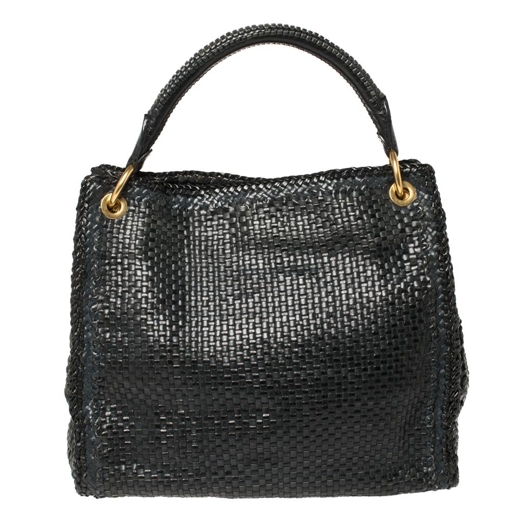 This eye-catching tote from Prada has a timeless charm. The bag is woven from leather in black and grey hues. It has dual round handles, gold-tone hardware, and protective metal feet at the bottom. Ideal for everyday use, the bag has enough space