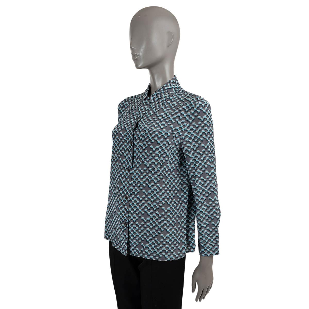 100% authentic Prada blouse in dark grey and light blue silk (100% - please note the content tag is missing). Features a blurry print and chest pocket. Closes with buttons on the front. Has been worn and is in excellent condition. 

2015
