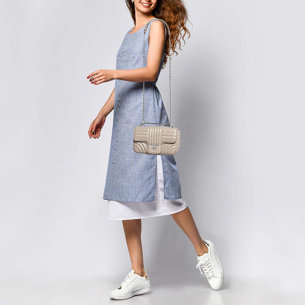 Swap that everyday tote with this charming crossbody bag from the house of Prada. The grey leather bag comes fitted with a shoulder strap and a flap closure embellished with the brand accent.