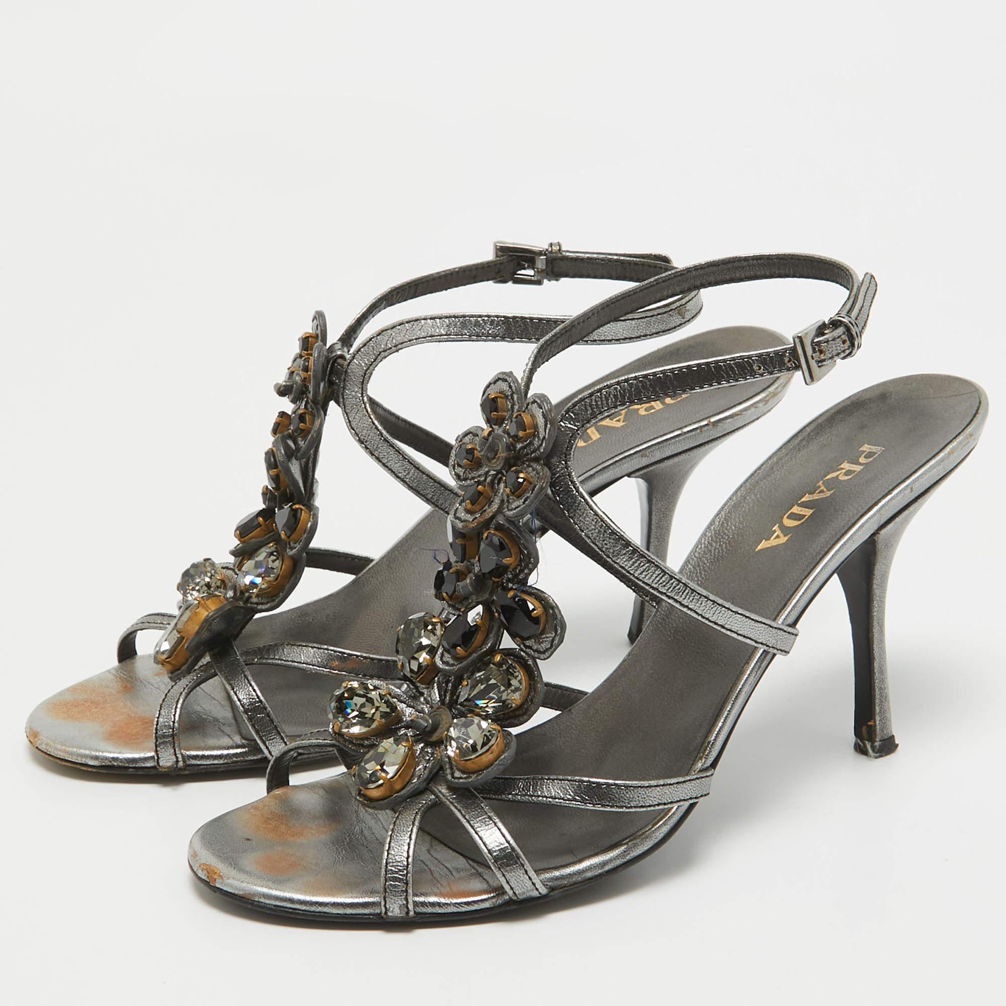 Walk in style and confidence with these sandals from the House of Prada. Crafted using grey leather these sandals are brilliantly embellished with crystals and set on tall 10cm heels. They showcase gold tone fittings and an ankle strap. These