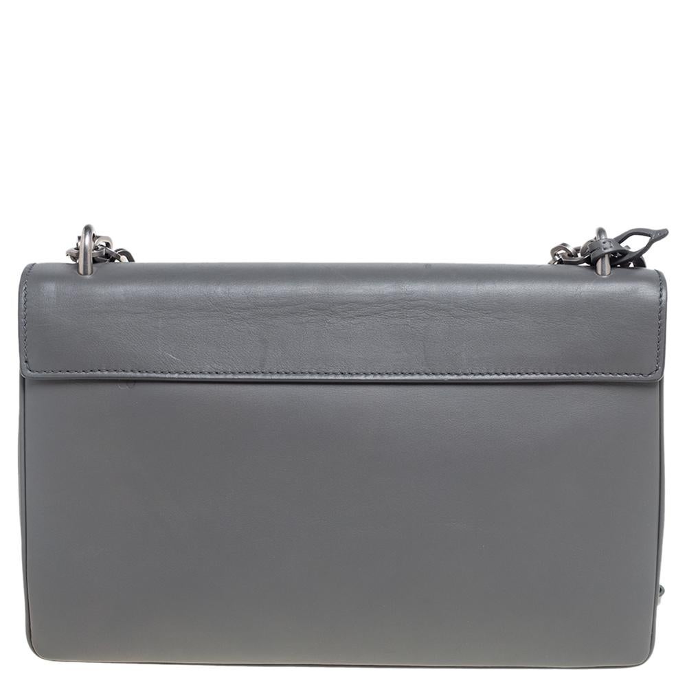 Prada has exclusively made this stately handbag in a lovely style flaunting a silver-tone engraved lock on the front flap. This grey leather bag with stunning features is a perfect pick for the season. The leather lining gives to its functionality.