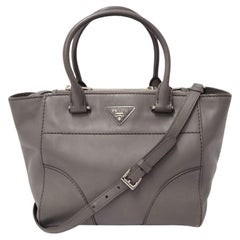 Borsa Prada in pelle grigia con manici superiori e placca logo in argento Borsa Prada in pelle grigia con manici superiori e placca logo in argento