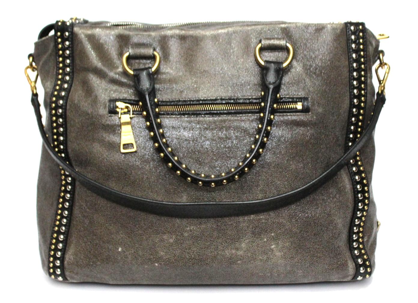 Prada large and special bag in satin gray leather with details and handles in black leather. Enriched with golden and silver studs.
Zip closure, large interior and pockets. Equipped with double handle and shoulder strap.
It is in good condition