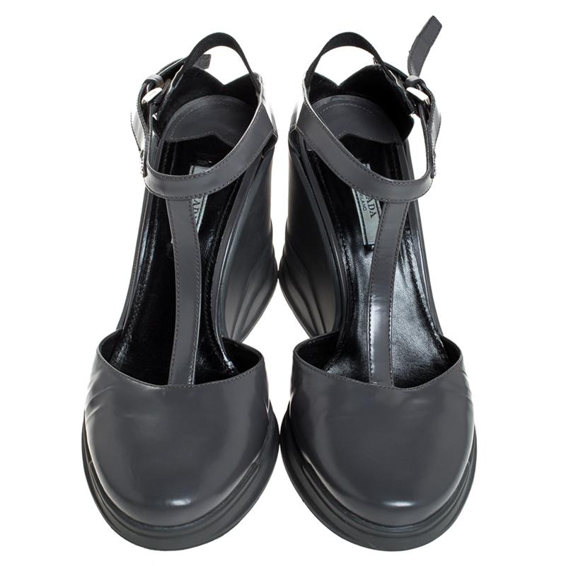 Wear these leather sandals when you go out and watch heads turn. Glam up your outfit with these rubber sole sandals. The grey sandals from Prada feature round toes, wedge heels and a T-strap design.

Includes: The Luxury Closet Packaging

